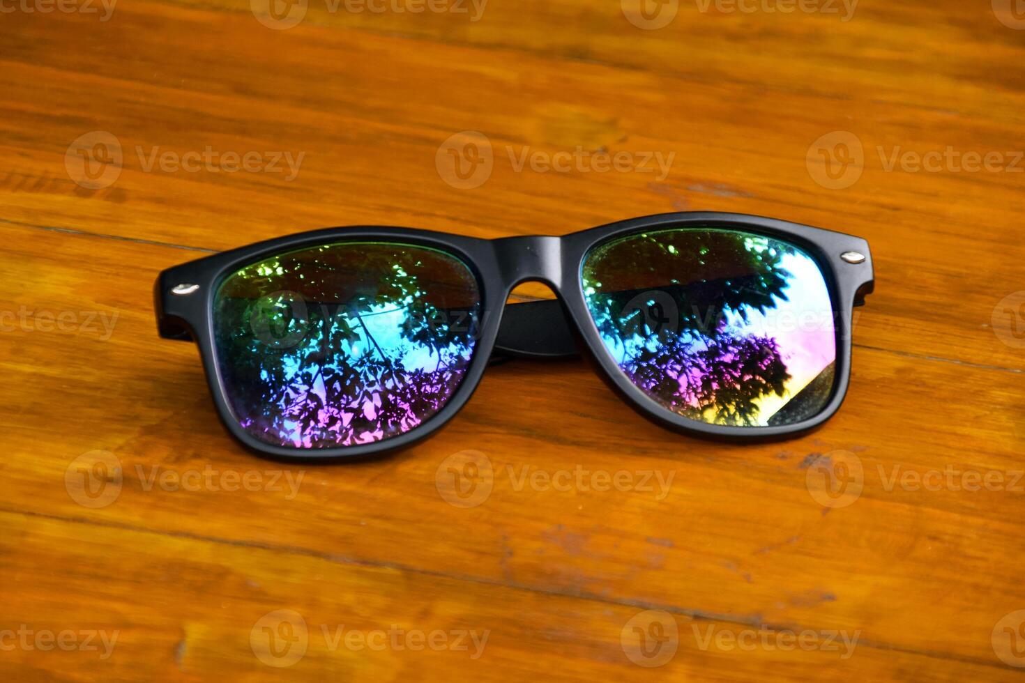 Close up of black stylish sunglasses on wooden table photo