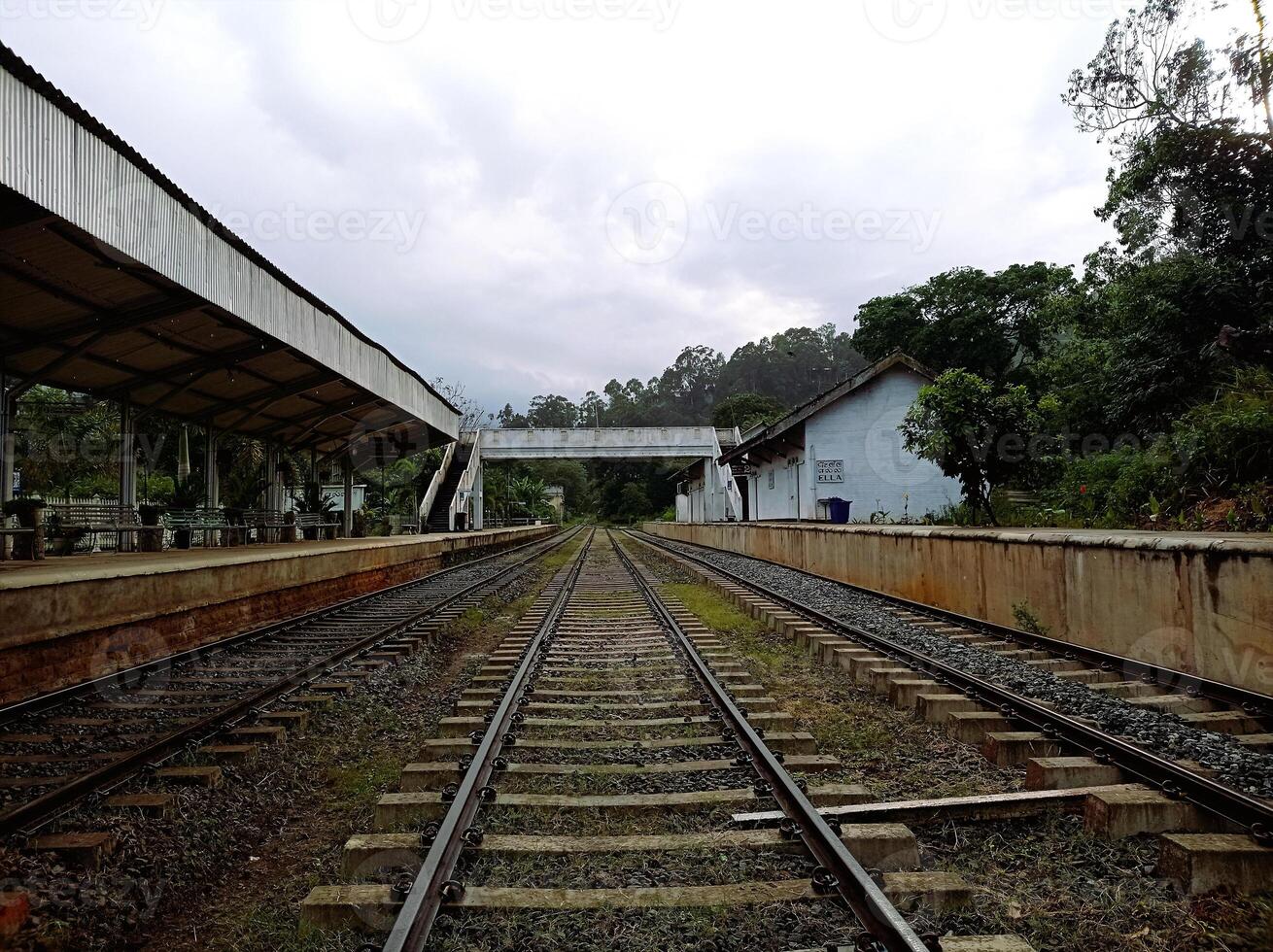 Completely empty railway station in Ella Sri Lanka with tracks and a bridge under a cloudy sky photo