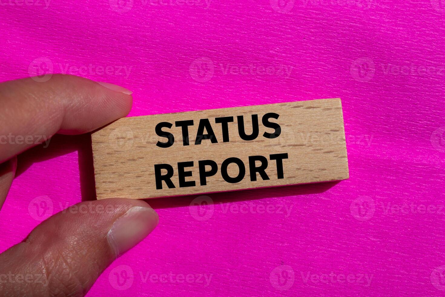 Status report message written on wooden block on pink background. Conceptual status report symbol. Copy space. photo