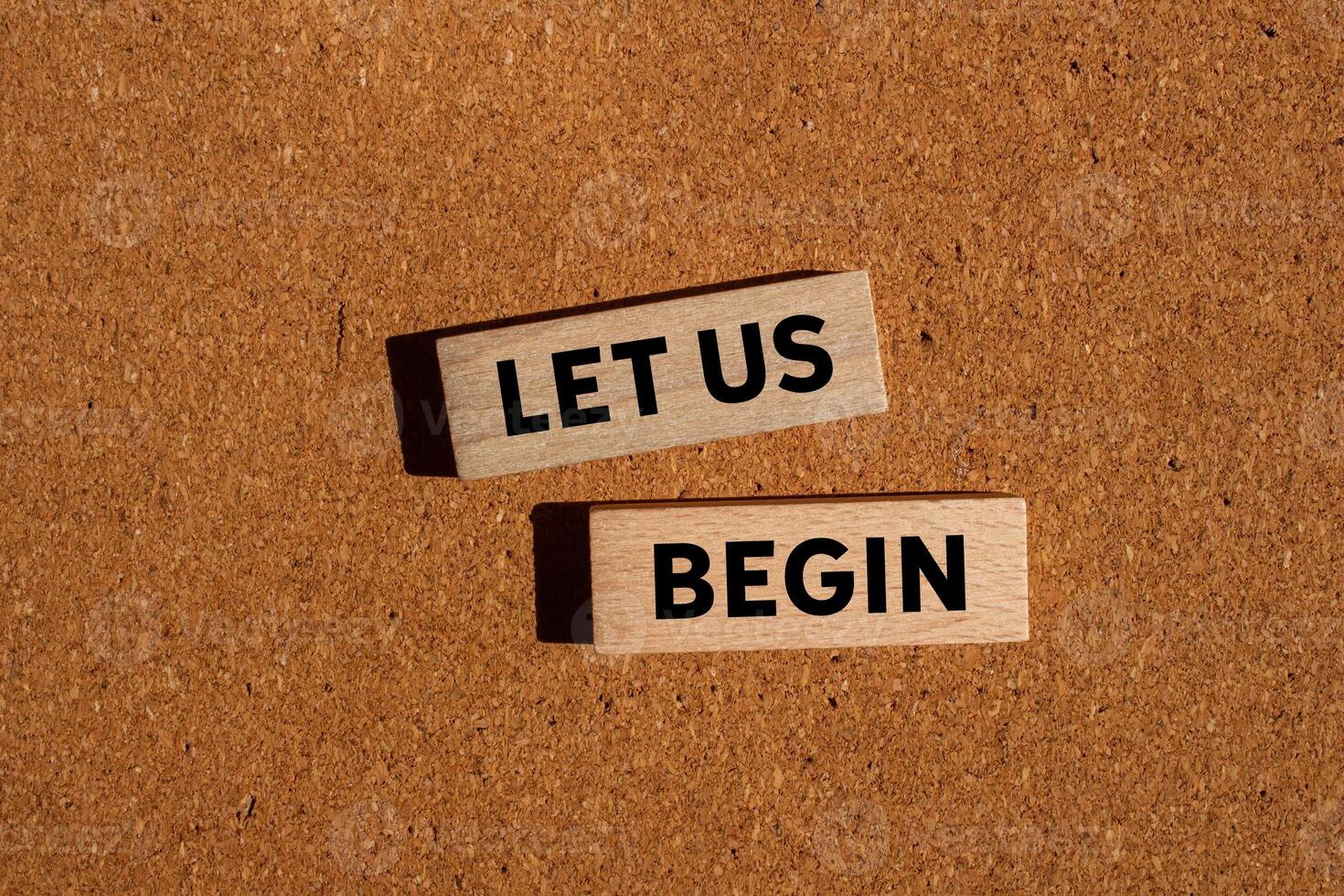 Let us begin message written on wooden blocks on brown background. Conceptual let us begin symbol. Copy space. photo