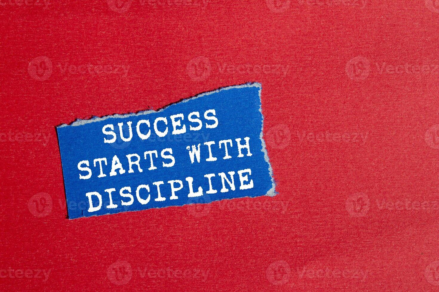Success starts with discipline message written on ripped torn blue paper piece on red background. Conceptual success starts with discipline symbol. Copy space. photo