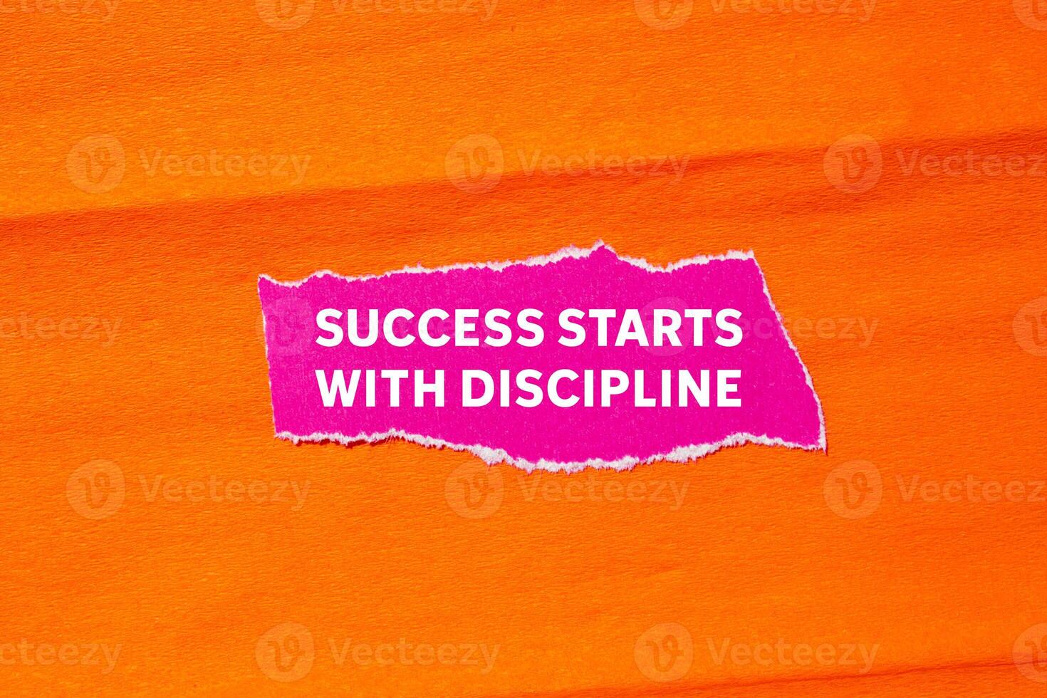 Success starts with discipline message written on ripped torn pink paper on orange background. Conceptual success starts with discipline symbol. Copy space. photo