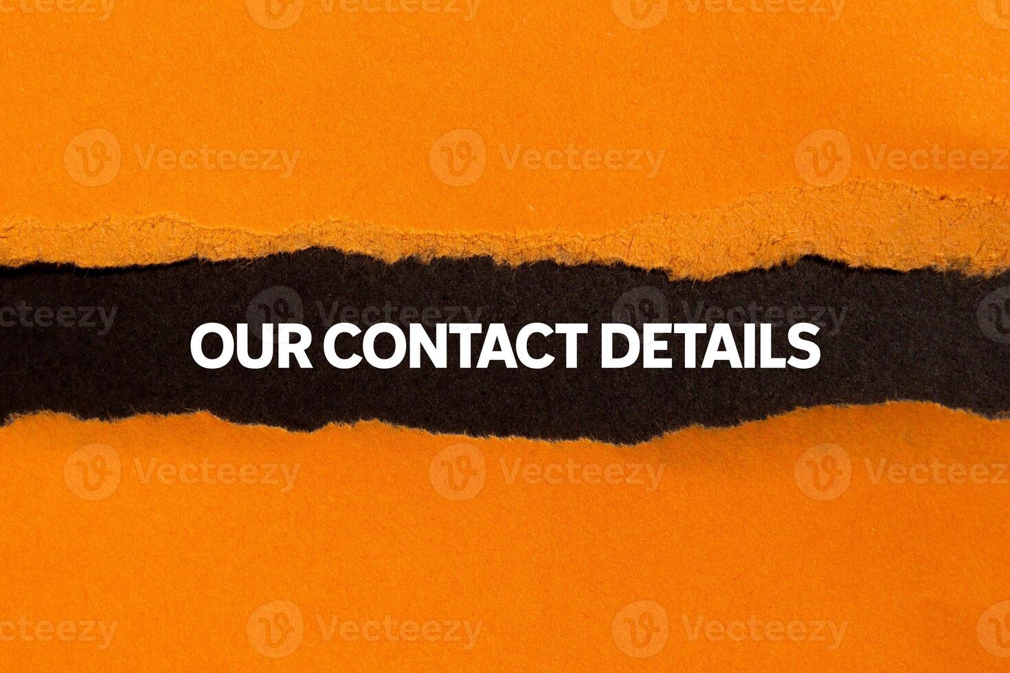 Our contact details message written on ripped torn orange paper on black background. Conceptual our contact details symbol. Copy space. photo