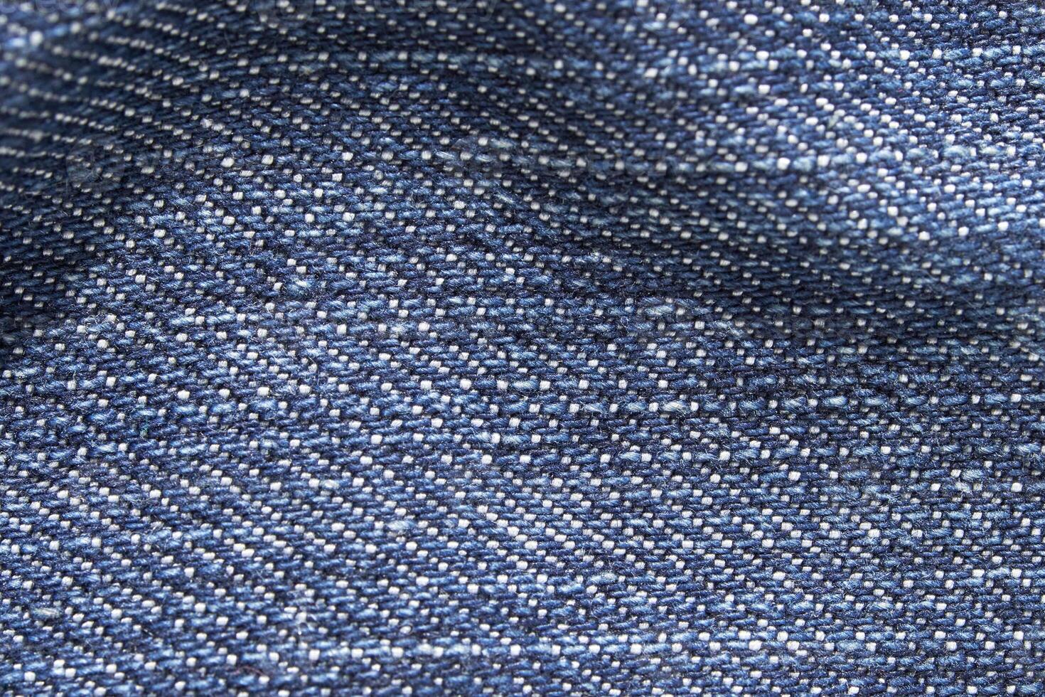 Close-up texture of blue denim fabric showing detailed weave pattern in high resolution. photo