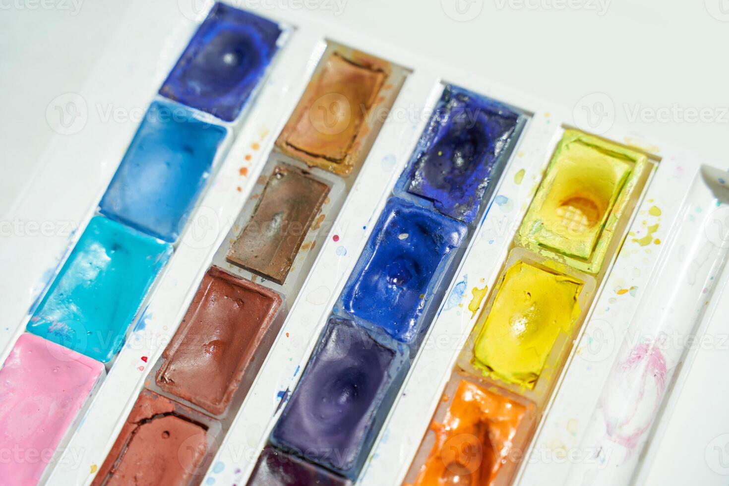 Bright watercolor palette with vibrant colors and used paint trays in sunshine. photo