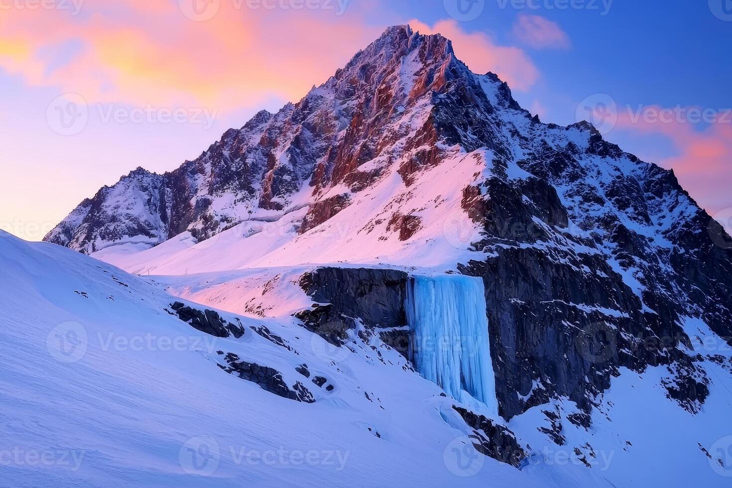 A breathtaking mountain scene featuring a majestic peak, cascading ice waterfall, and vibrant sunset colors illuminating the snow-covered landscape. photo