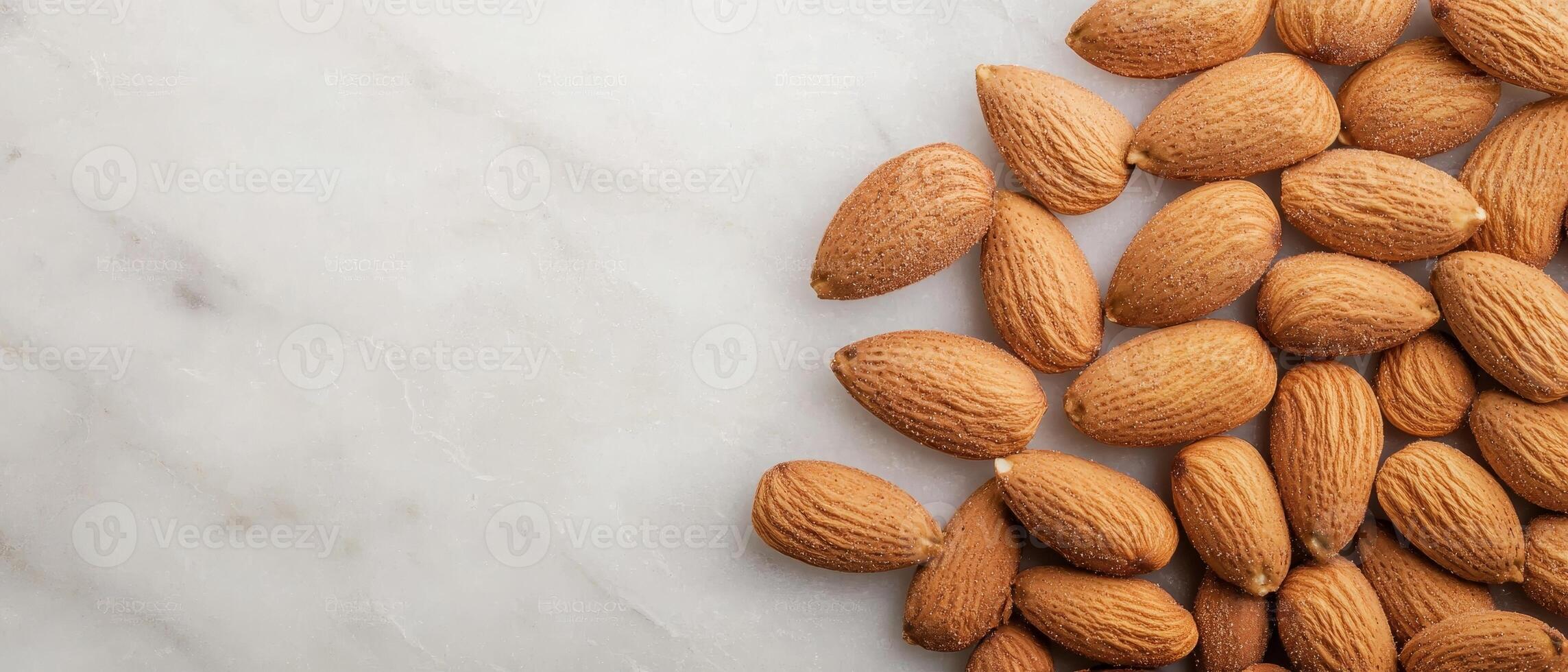 A close-up view of scattered almonds on a marble surface, showcasing their textured shells and natural color. photo