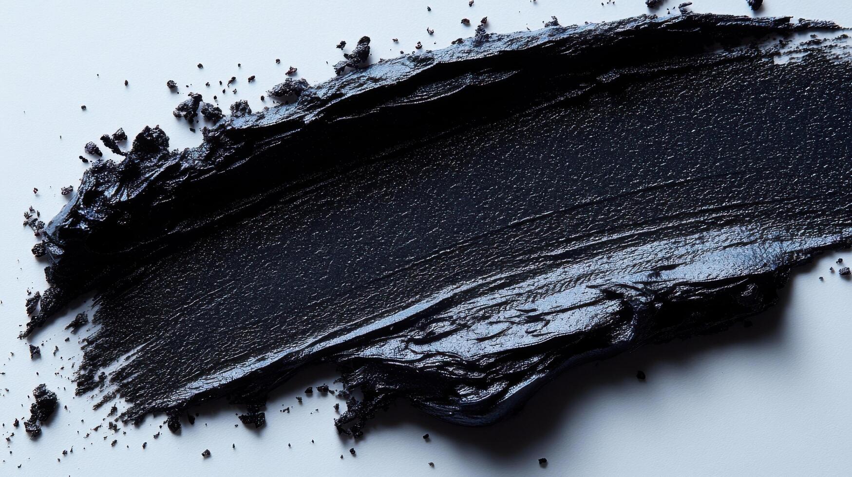 Thick black paint smeared across a smooth surface during an art project in a creative studio photo
