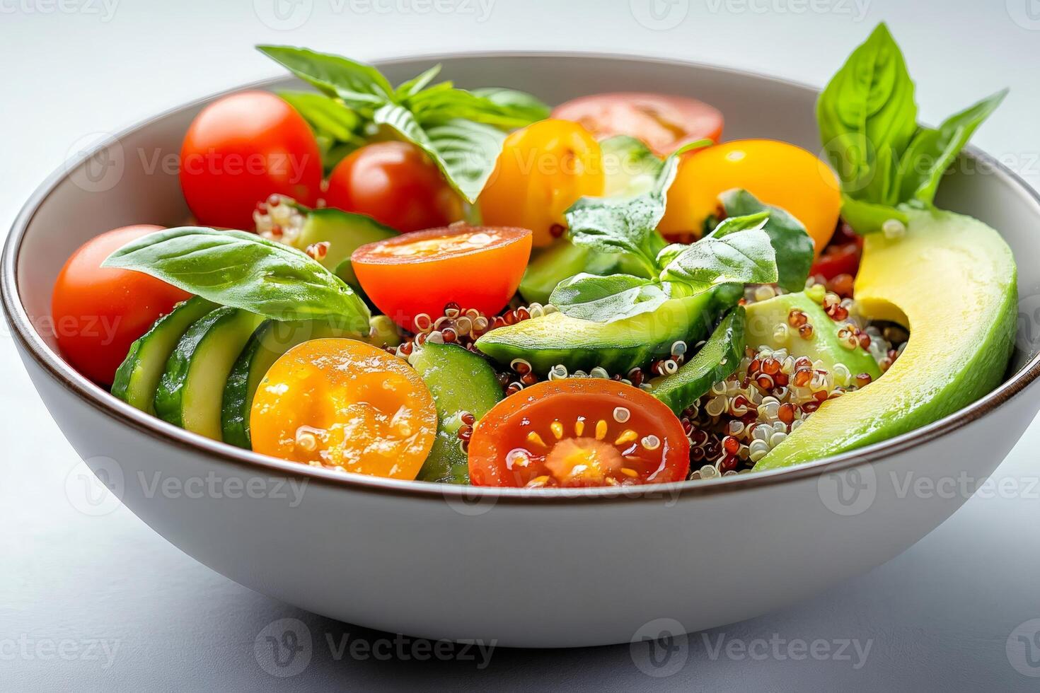 Bowl of healthy quinoa salad with avocado, cucumber and cherry tomatoes photo