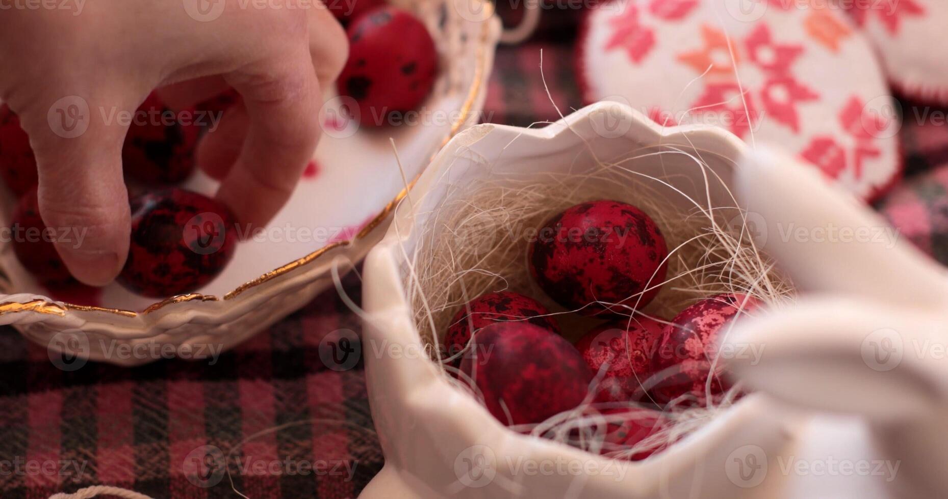 Decorating Easter eggs with vibrant colors while placing red eggs into a ceramic holder photo