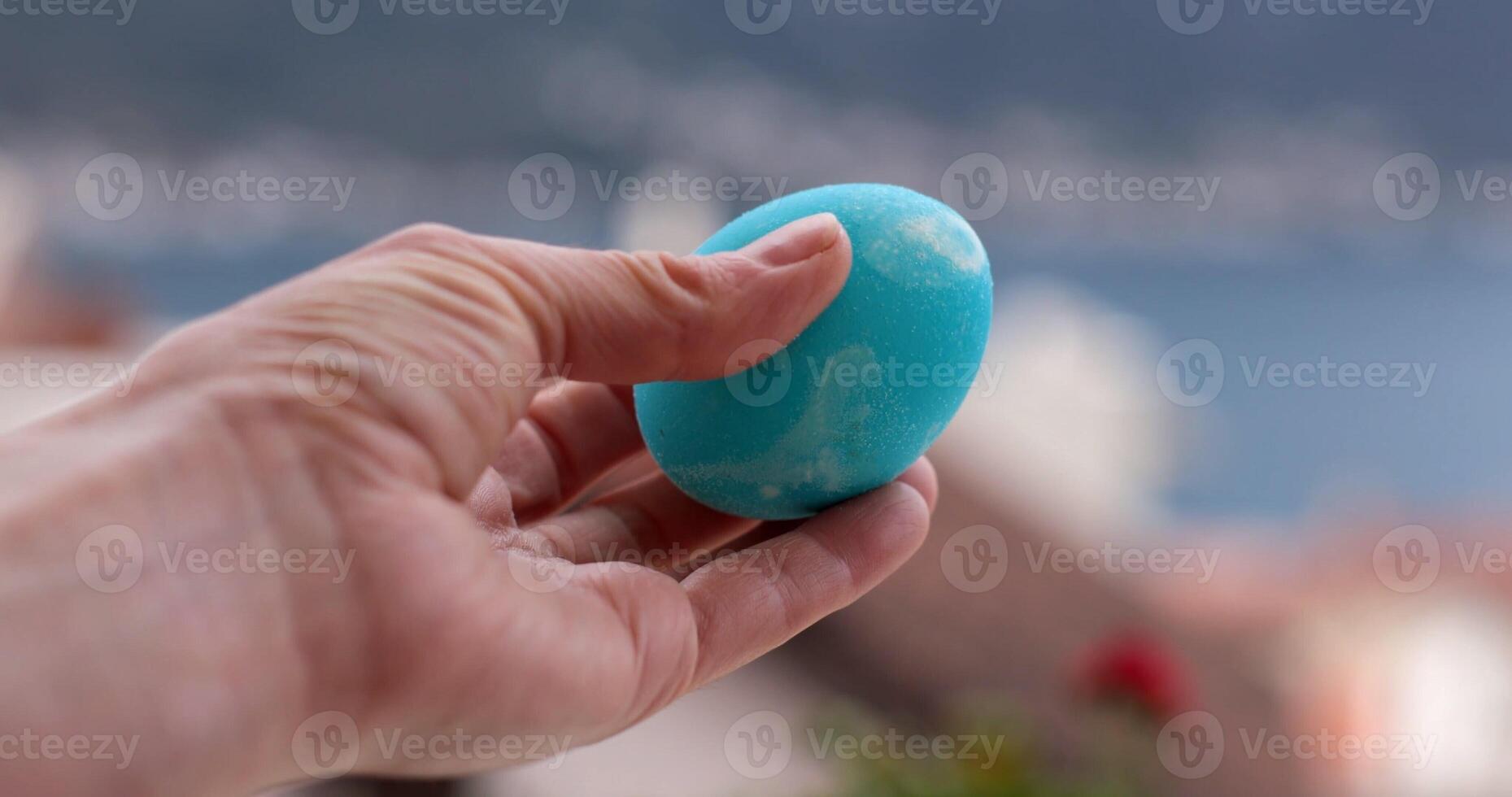 Coloring Easter eggs in turquoise shade for festive celebrations while enjoying a scenic view photo