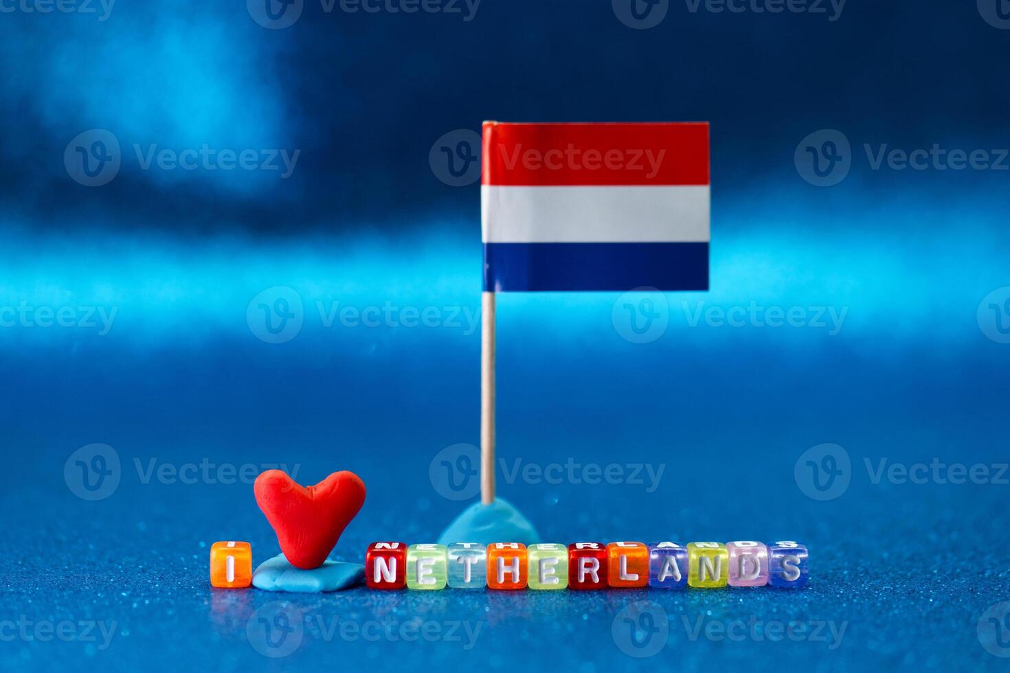 Colorful decorations displaying love for Netherlands with a small flag and heart on a vibrant blue surface during an artistic arrangement photo