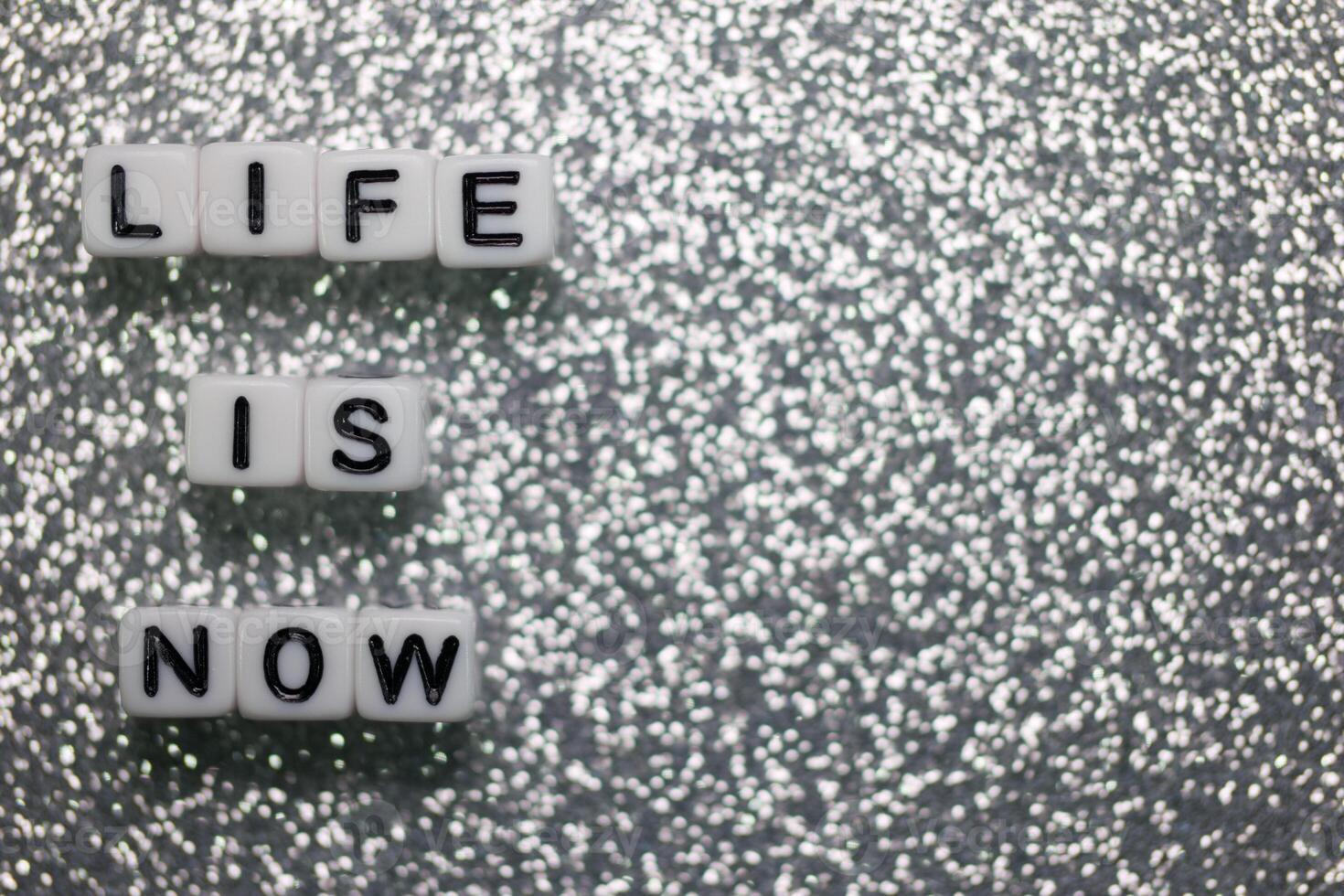Words spelling life is now arranged on a sparkling surface to inspire and motivate viewers to embrace the present moment photo