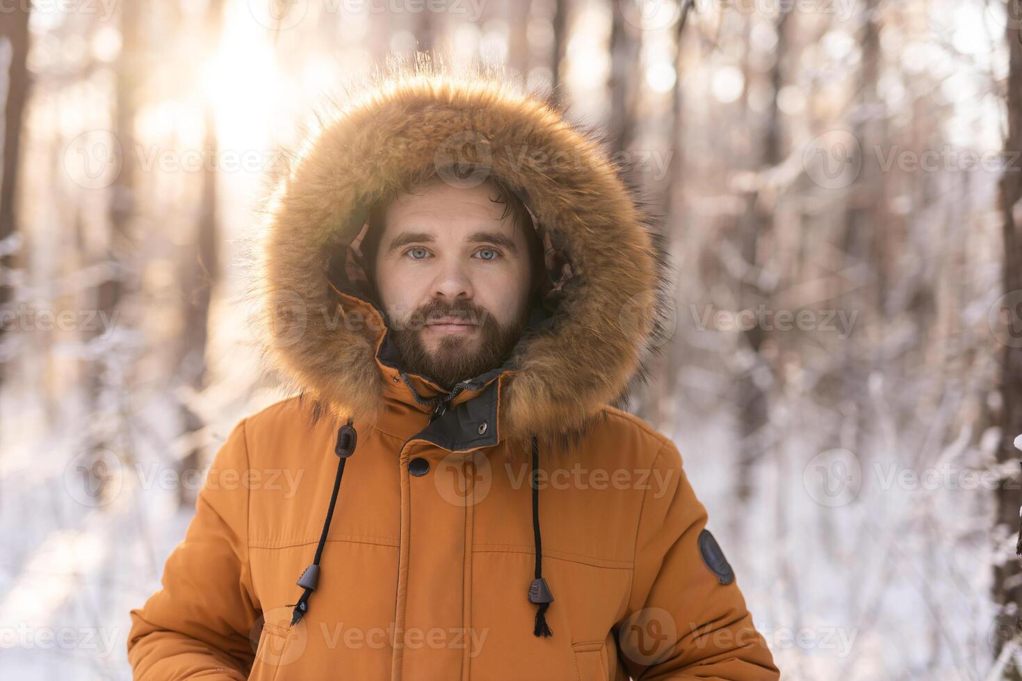 Man in winter coat standing in snowy forest at sunrise. Solitude, connection with nature, and quiet winter contemplation outdoors. Copy space photo