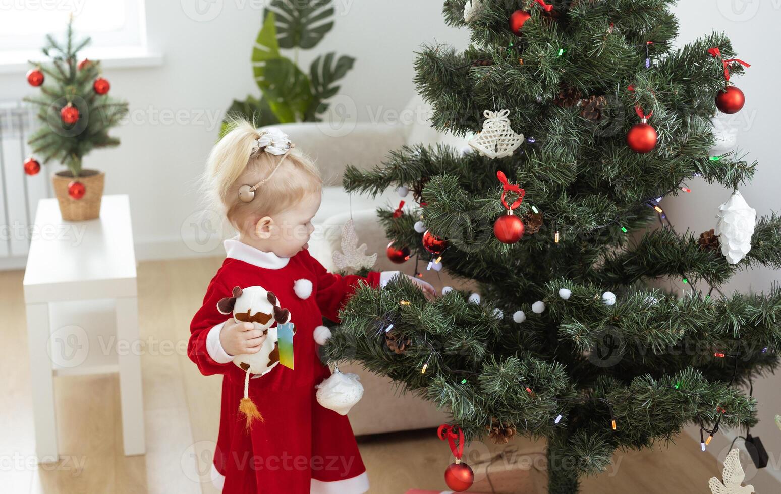 Toddler child with cochlear implant decorating christmas tree - deafness and diversity and innovating medical technologies for hearing aid photo