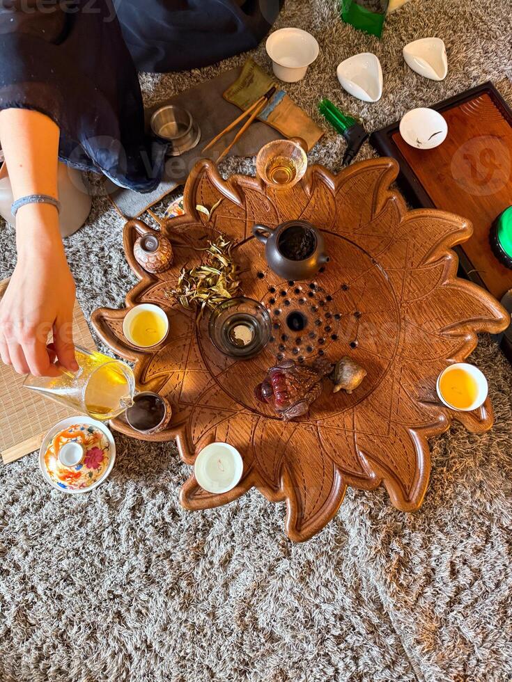 A woman prepares loose leaf tea during a traditional tea ceremony with friends. Community, mindfulness and the ritual of sharing tea photo