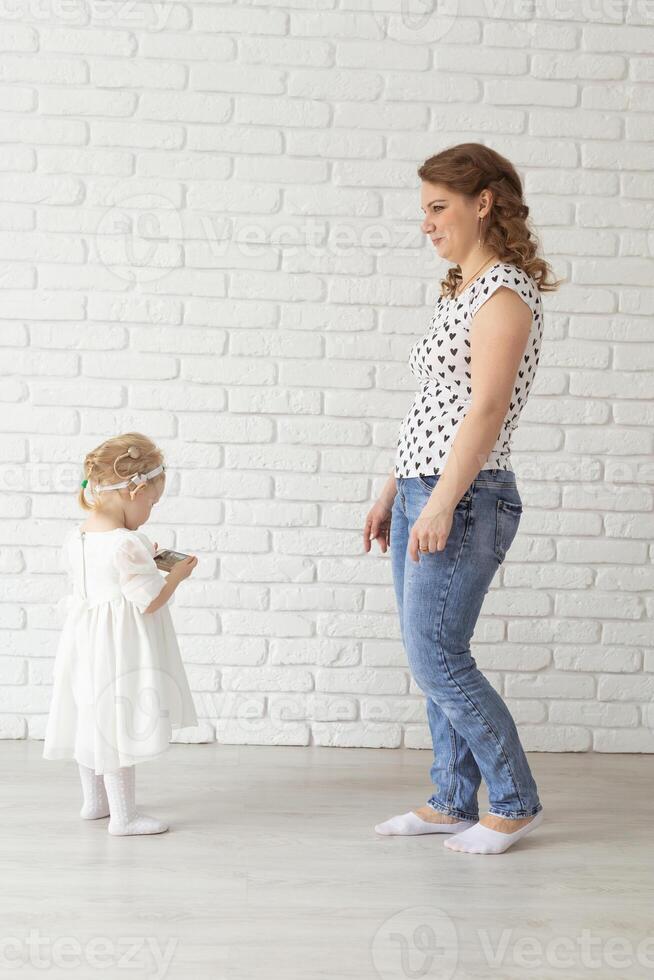 Child with cochlear implant hearing aid having fun with mother - diversity and deafness treatment and medical innovative technologies photo