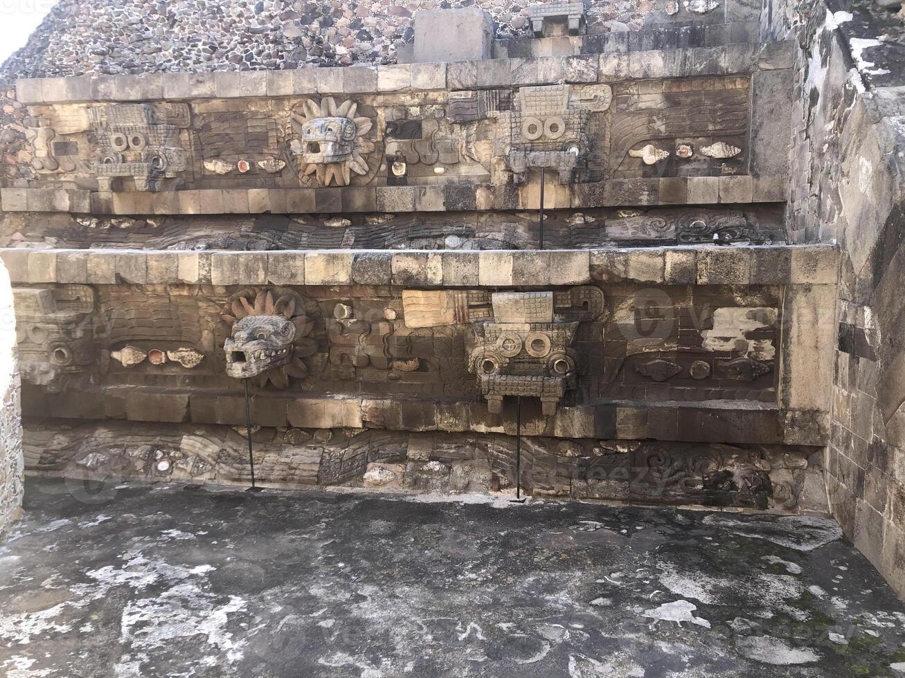 Carved heads depicting feathered snake heads in the Quetzalcoatl temple in Teotihuacan, Mexico. Pyramid in honor of God Quetzalcoatl represented by serpent feathered heads. photo