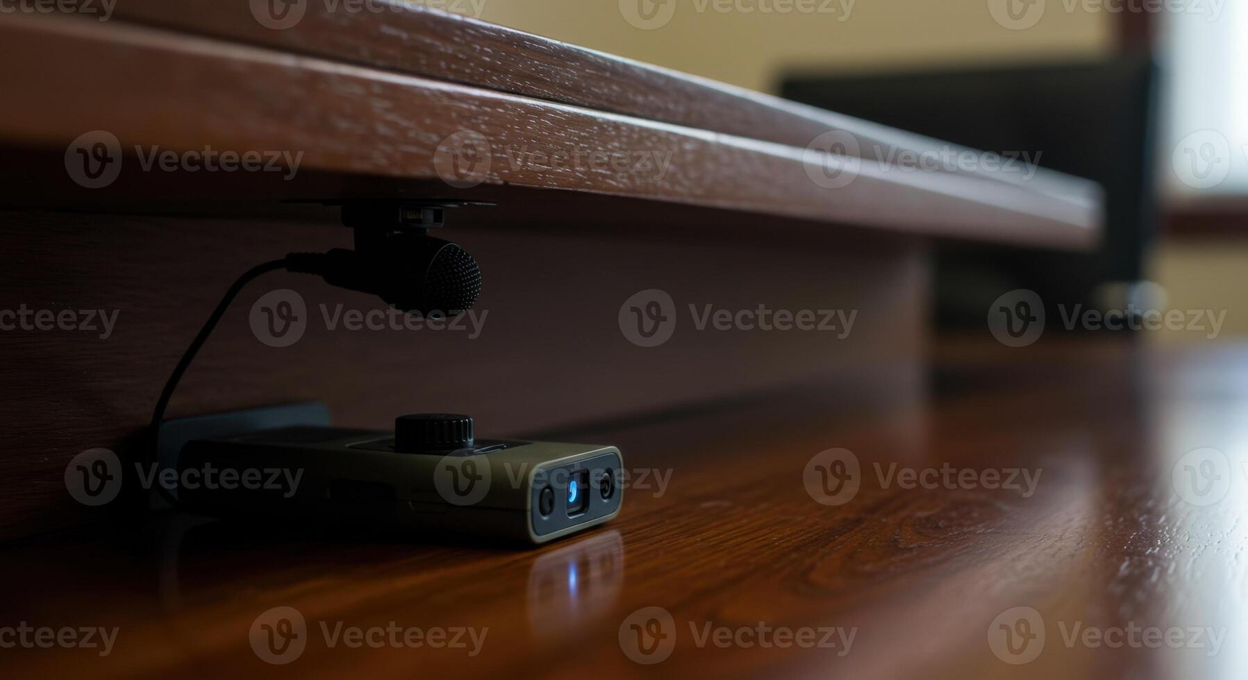 Using Microphone and Recorder for Audio Recording Under Wooden Desk photo