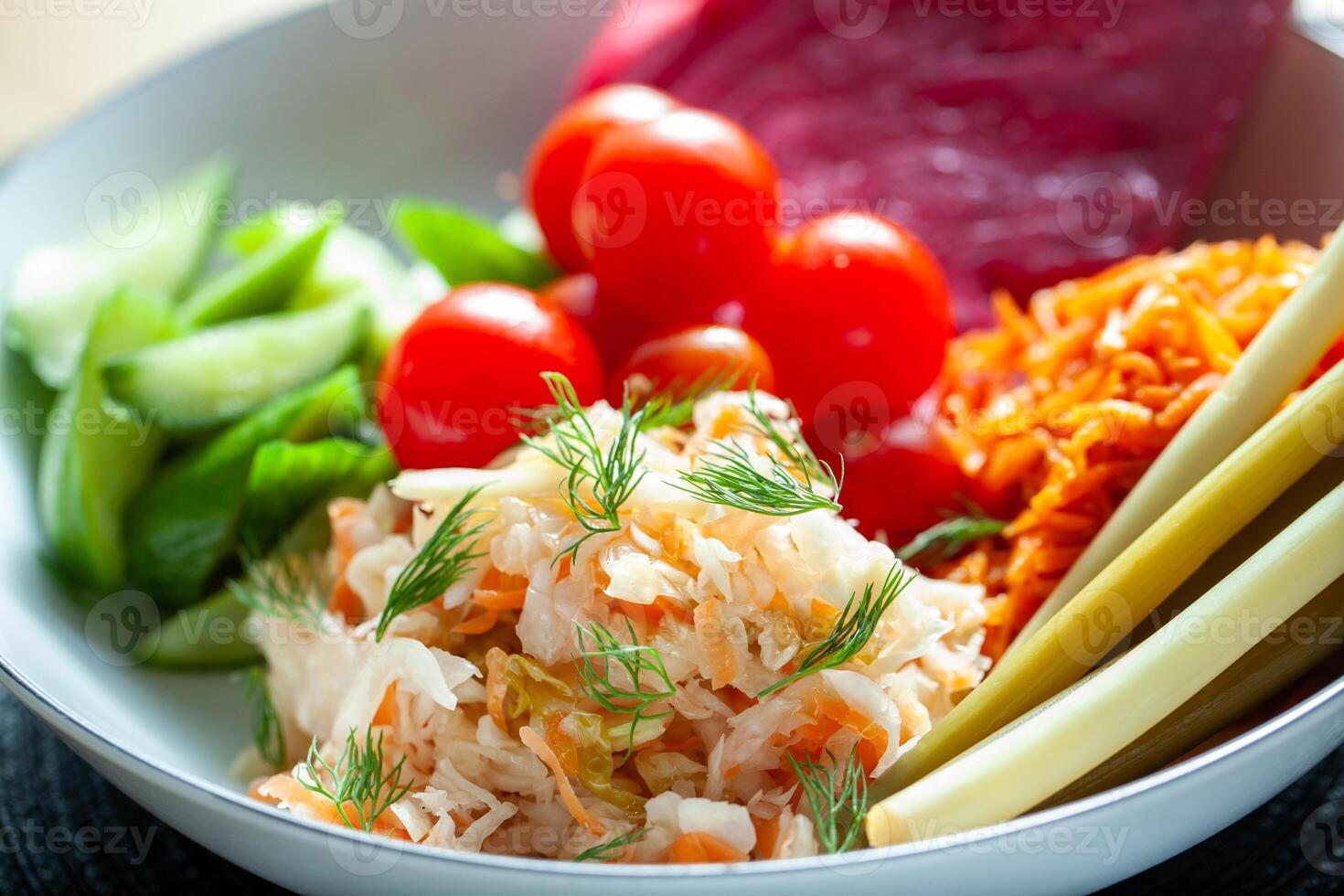 Traditional Russian pickled vegetables including sauerkraut and tomatoes served in a bowl with dill garnish photo