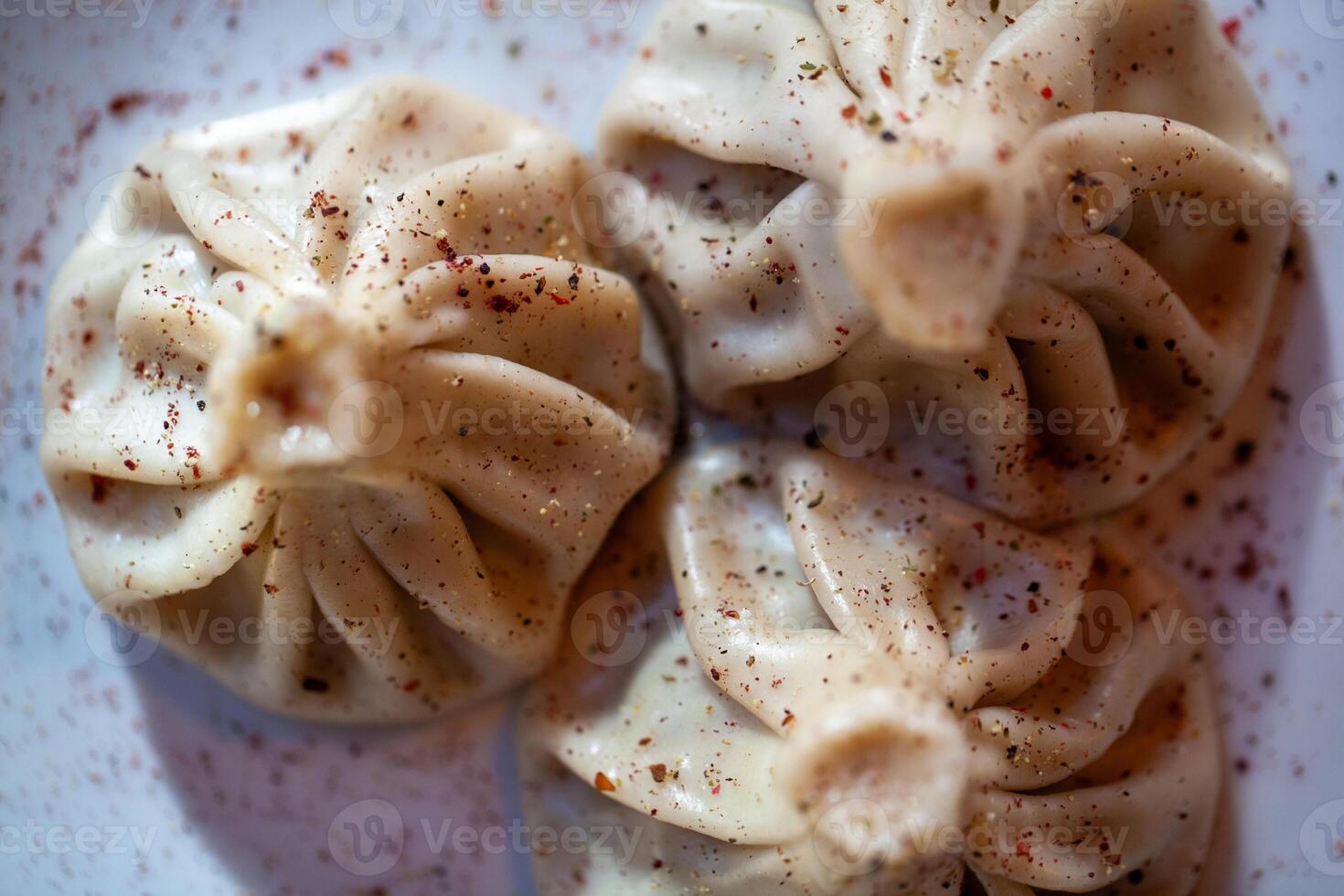 Khinkali dumplings dusted with spices on a plate shot in closeup detail showing texture photo