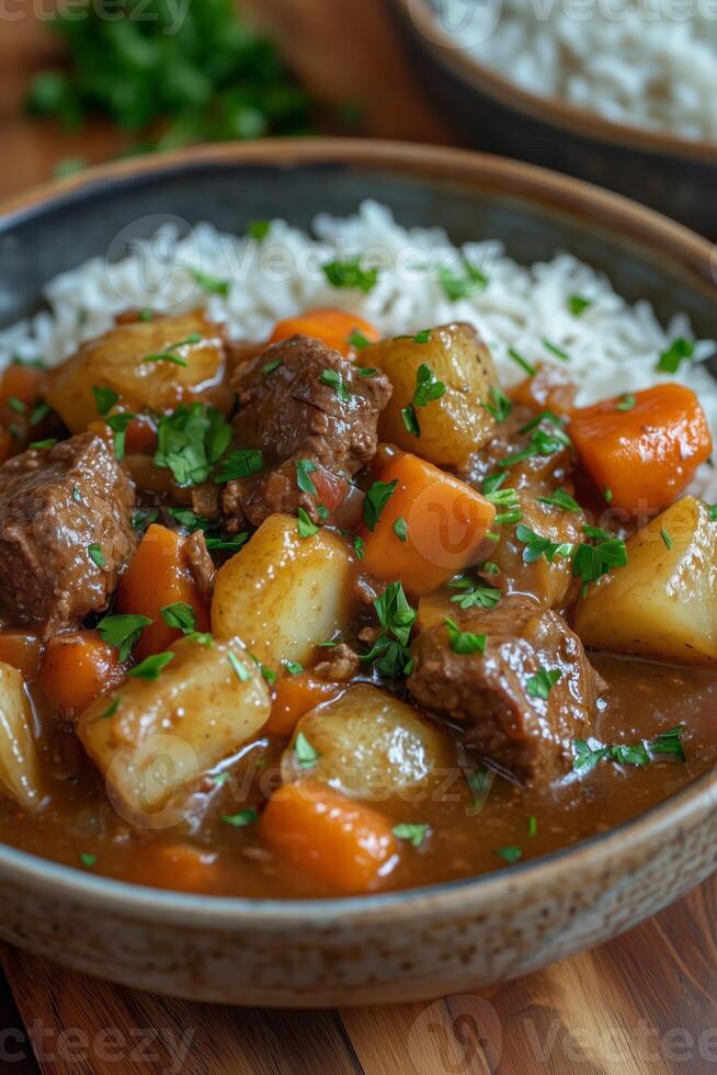 Bowl of hearty beef stew with potatoes and carrots, served with rice photo