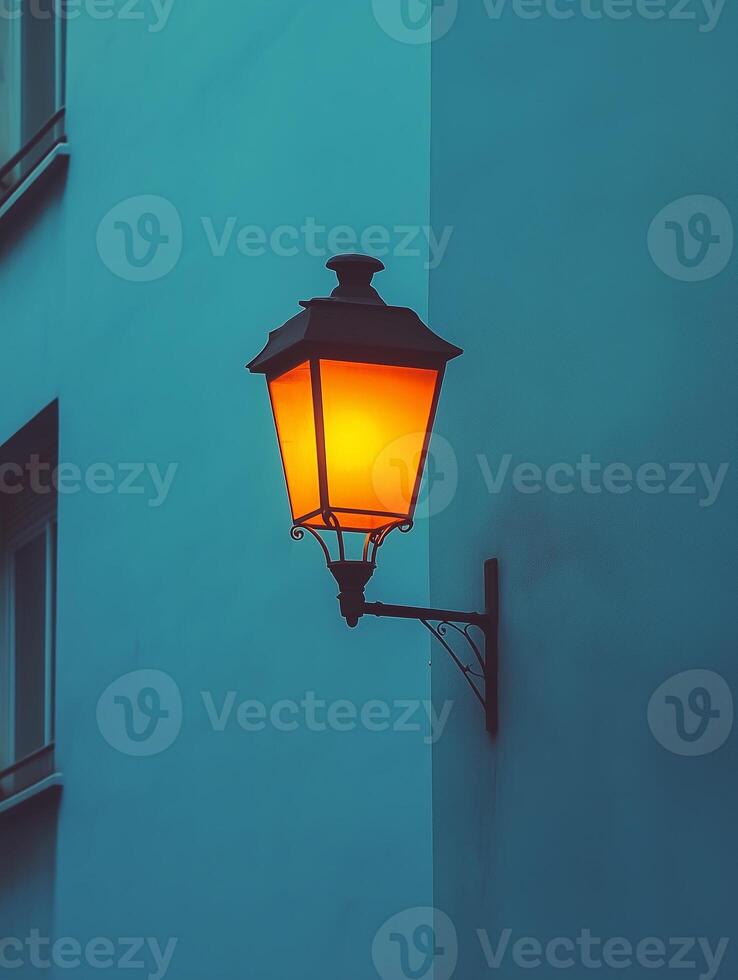 Warm street lamp illuminating building corner at dusk photo