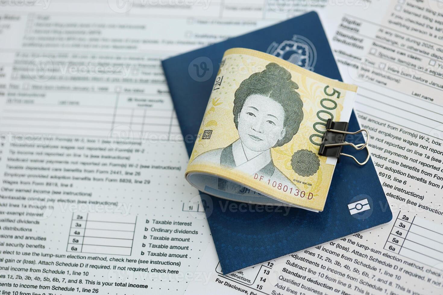 South Korean won money bills in big amount lies on table with passport and tax forms close up photo