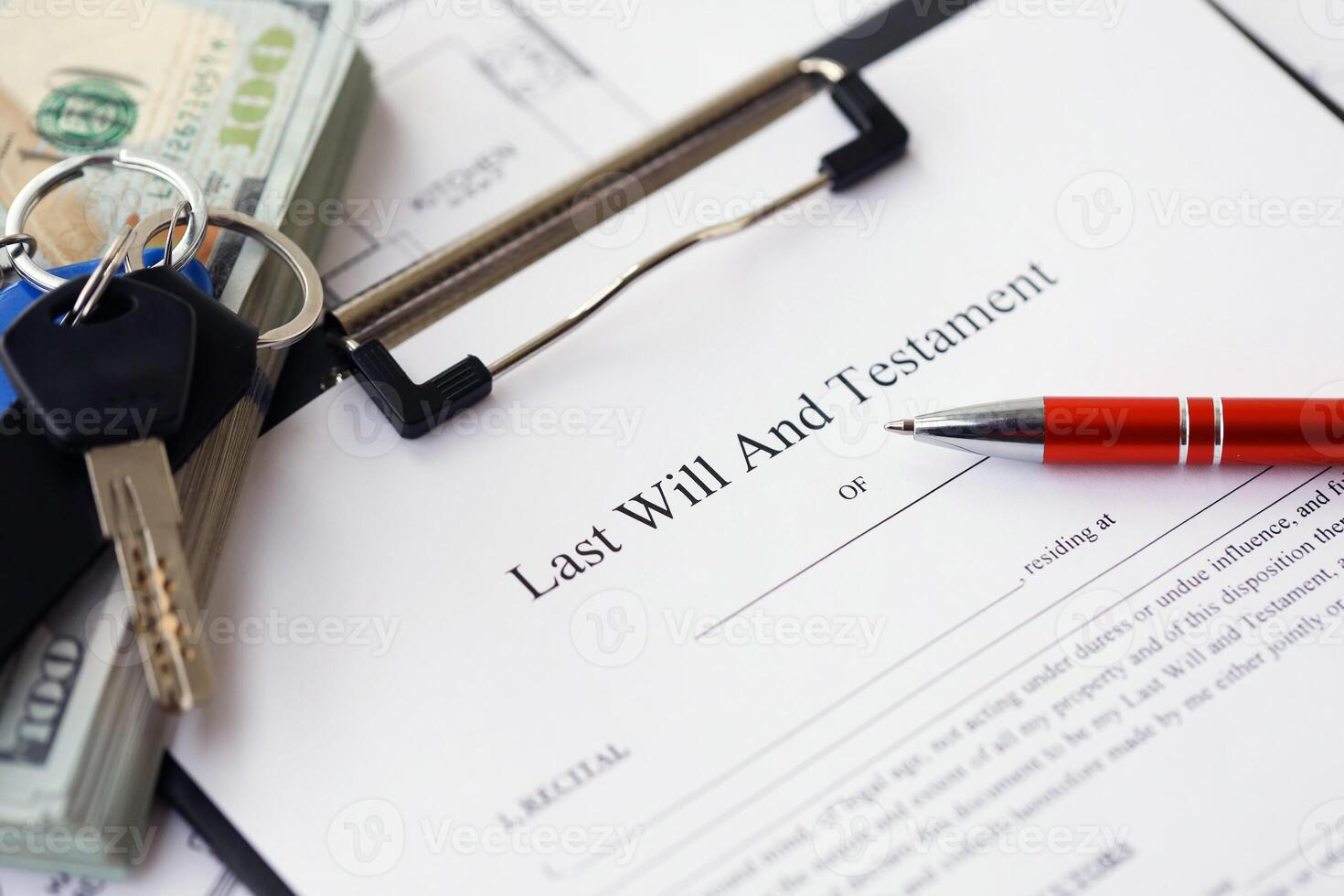Pen and keys on Last will and testament form and planning blueprints of residential building project photo