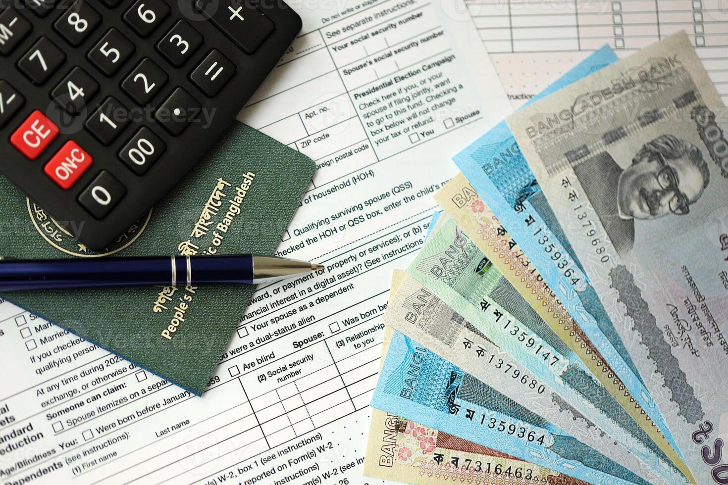 Bangladesh money bills lies on table with pen, calculator, passport and tax forms photo