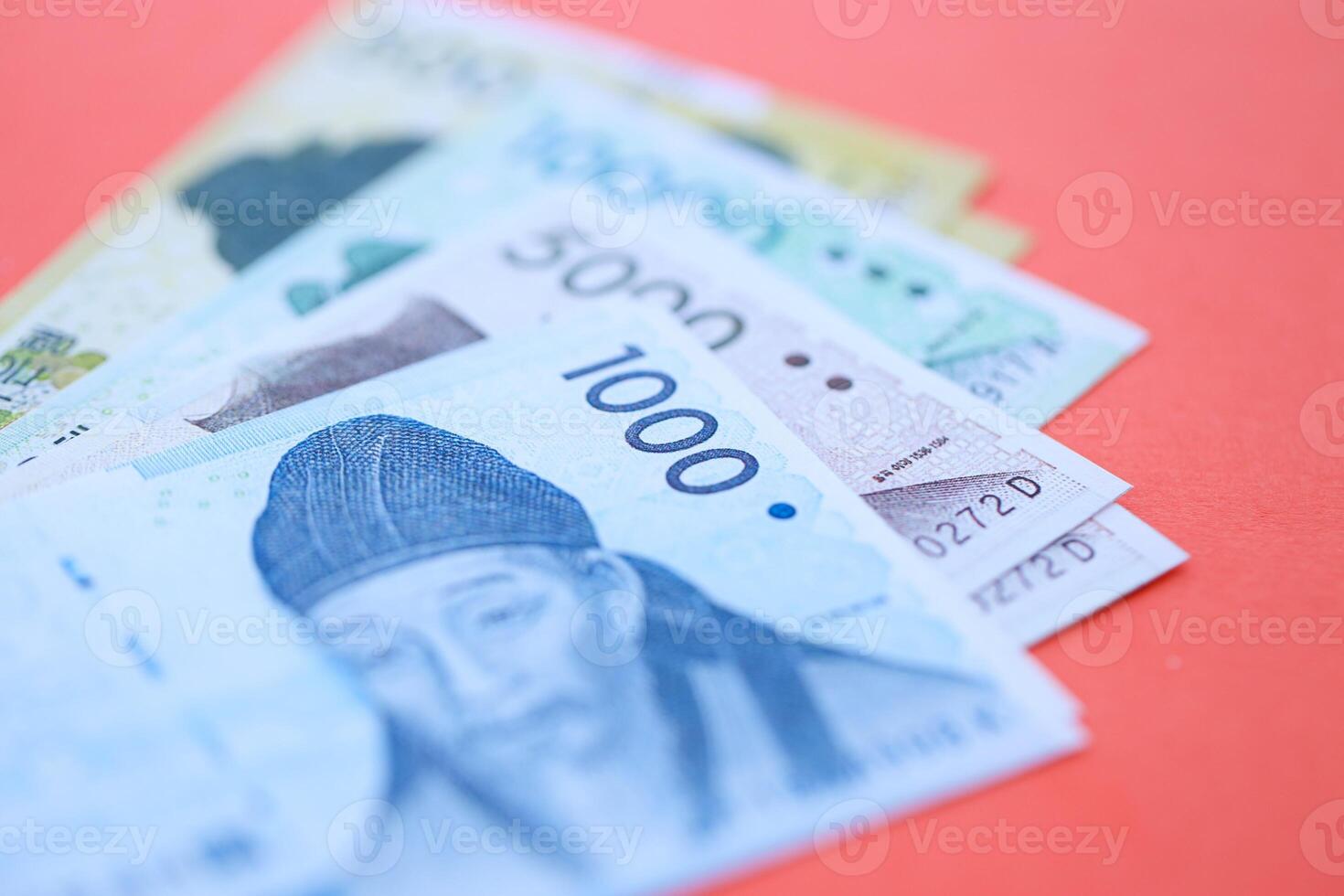 South Korean bills in big amount lies on red color table photo