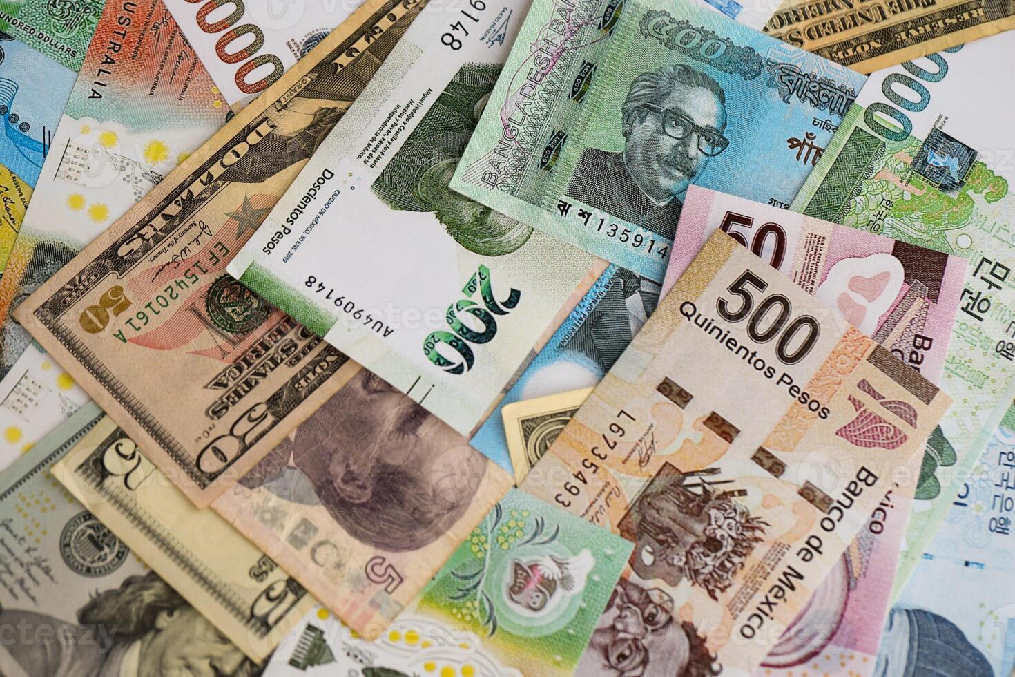 Big amount of money bills of different currencies and countries. Assortment background of international cash in big pile close up photo