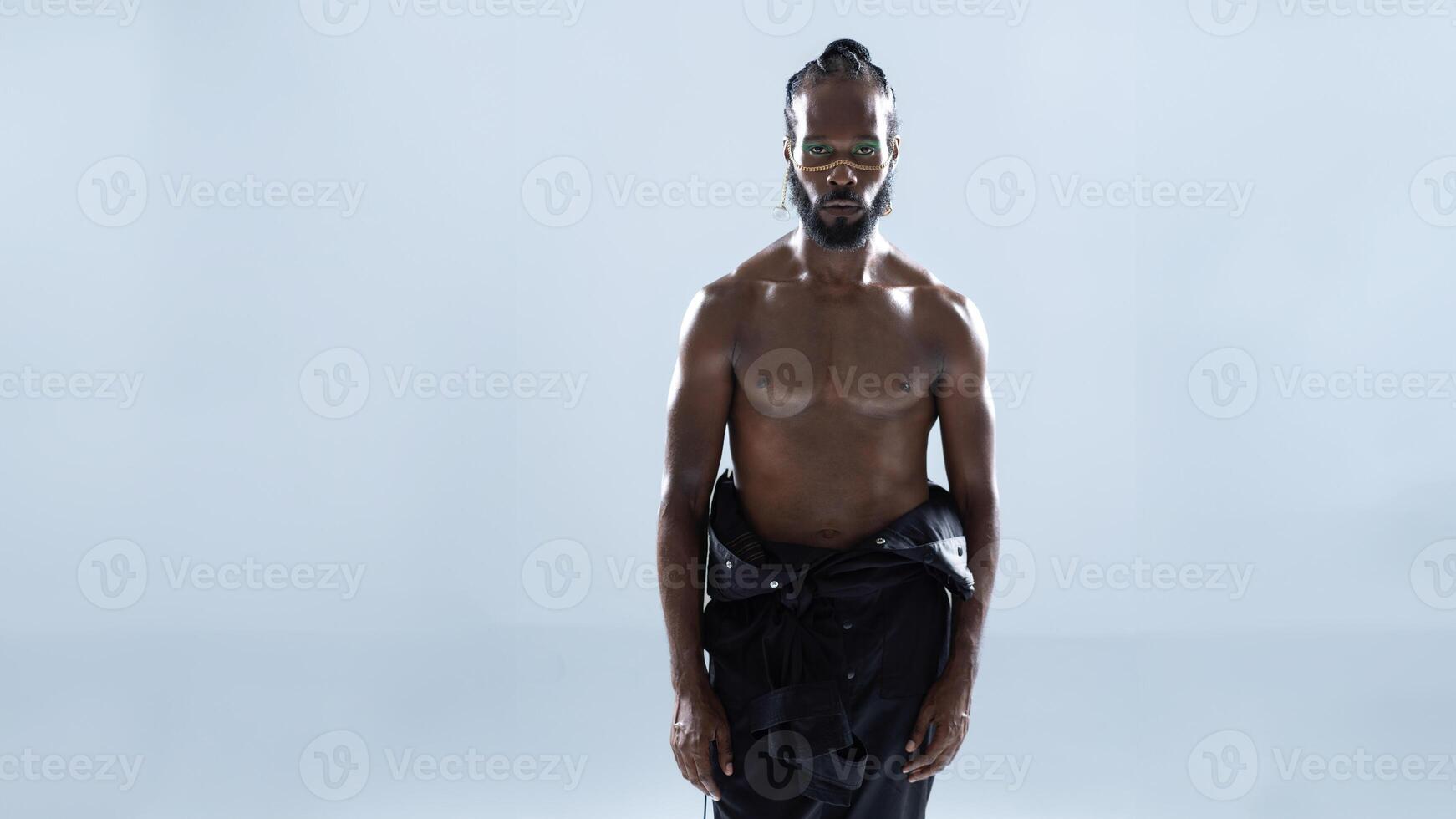 Shirtless African American gay man with bright makeup looking at camera photo