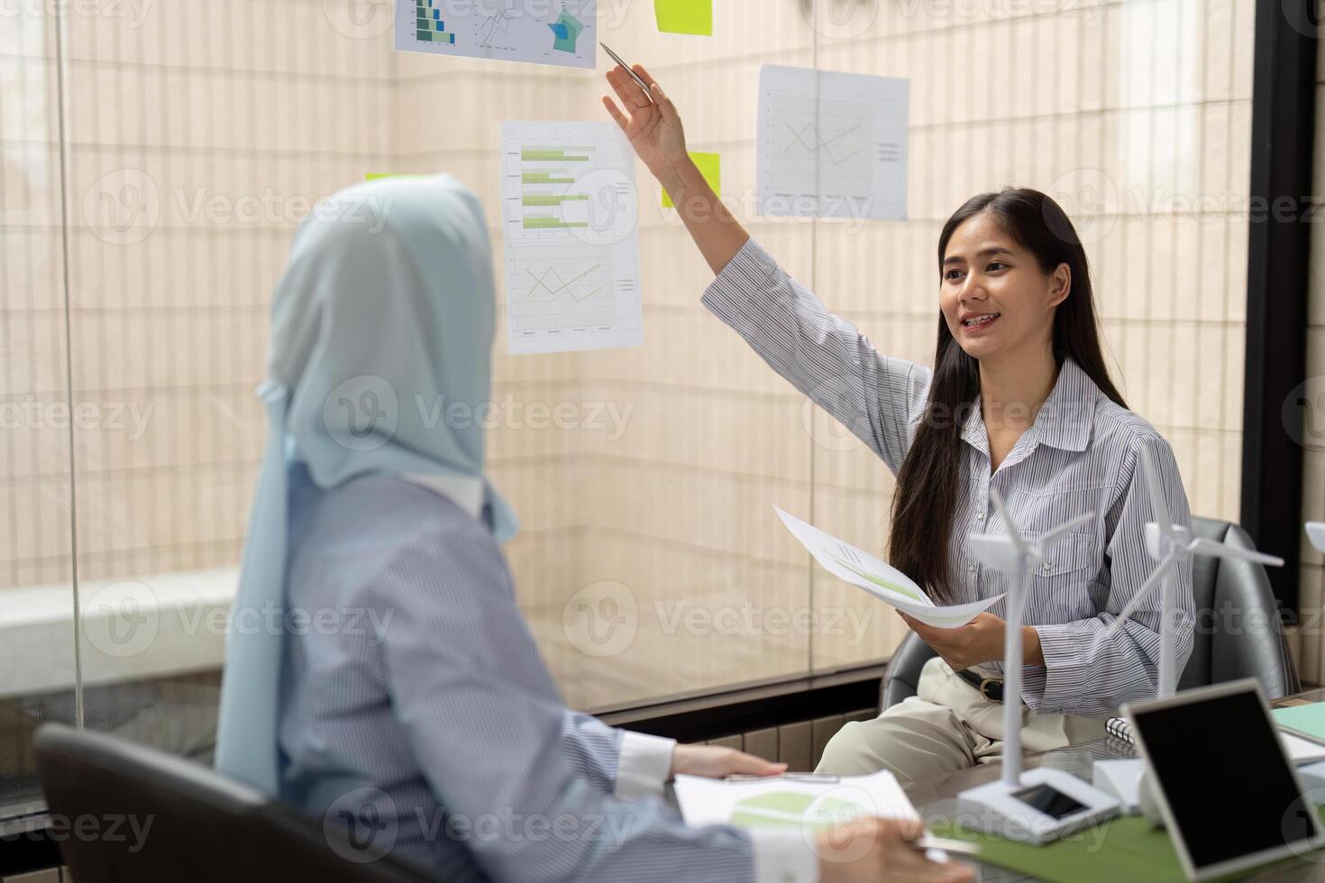 Engagement and Reporting. A professional presenting sustainable strategies using visual aids in a modern office. photo