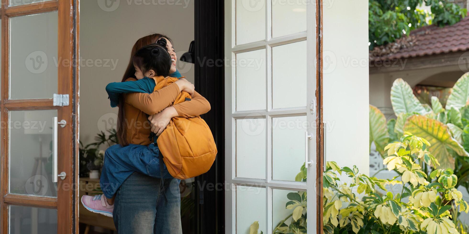 Connecting and Cherishing Family Moments. A mother lifts her daughter with love as they both smile at home. photo