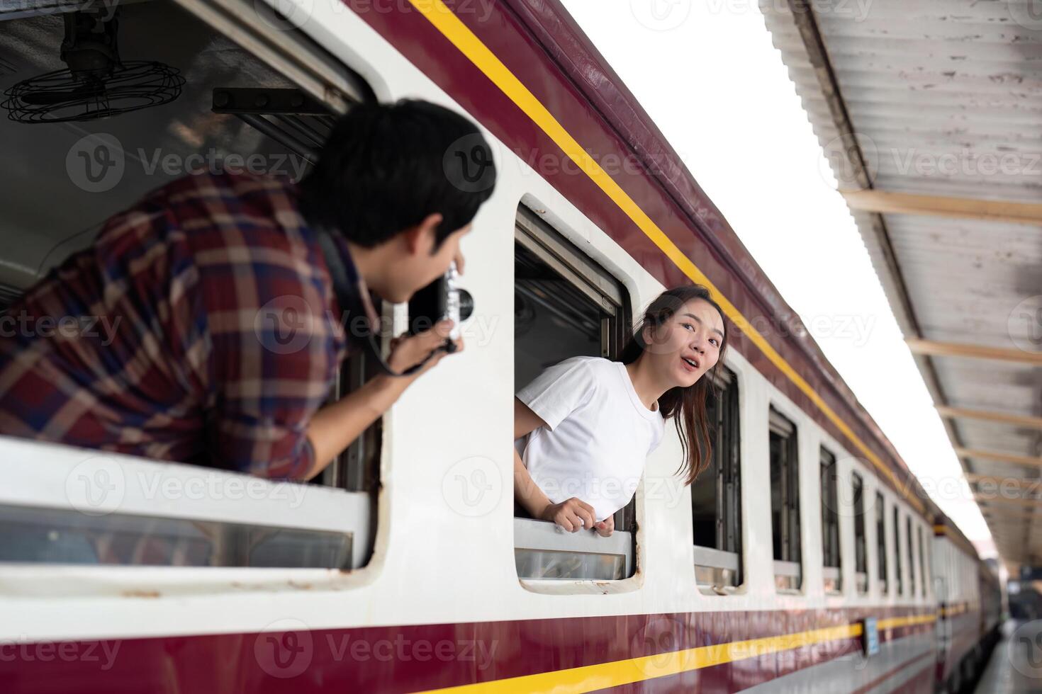 Travel and Adventure. A joyful couple capturing memories together on a train platform. photo