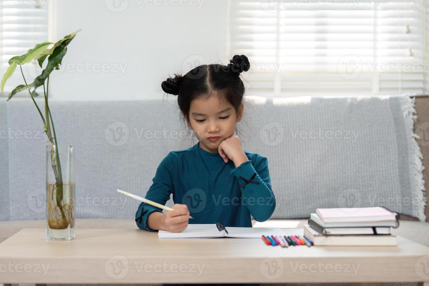 Concentration and Creativity. A young girl writes in her notebook at home, reflecting on her learning journey. photo