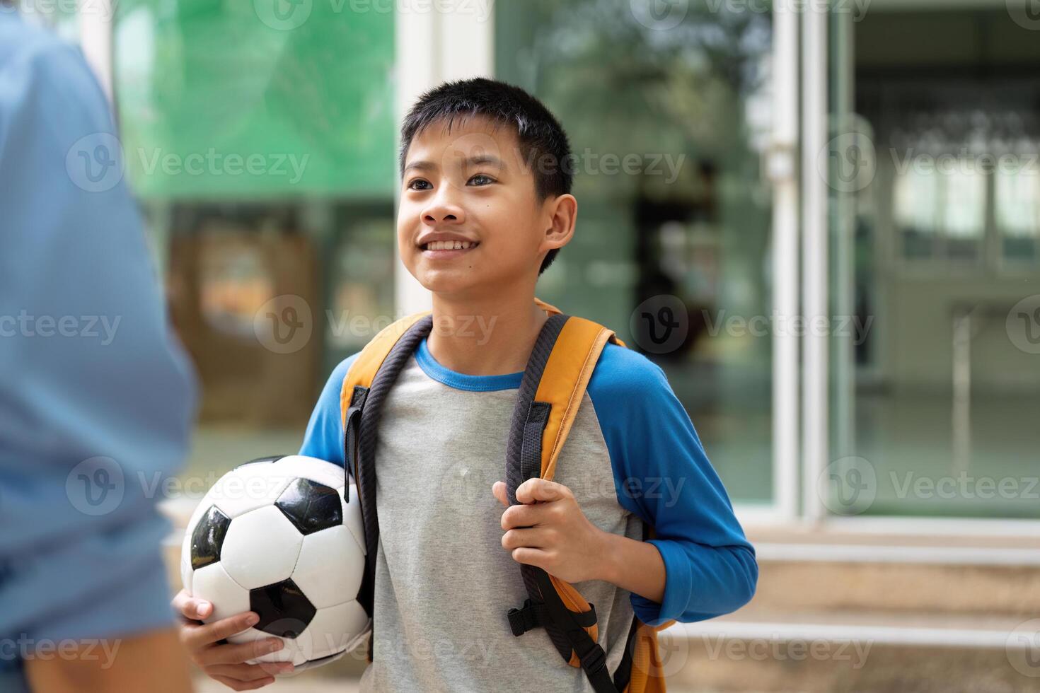 School Day and Happy Returns. A smiling boy showing off his soccer ball after a day at school. photo