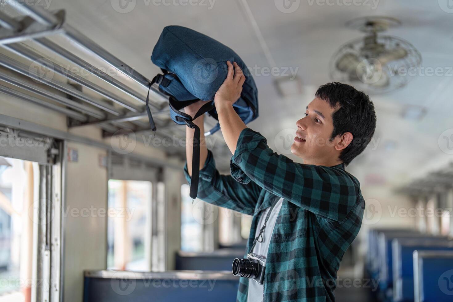 Preparation and Journey. A young traveler organizing his backpack inside a train. photo