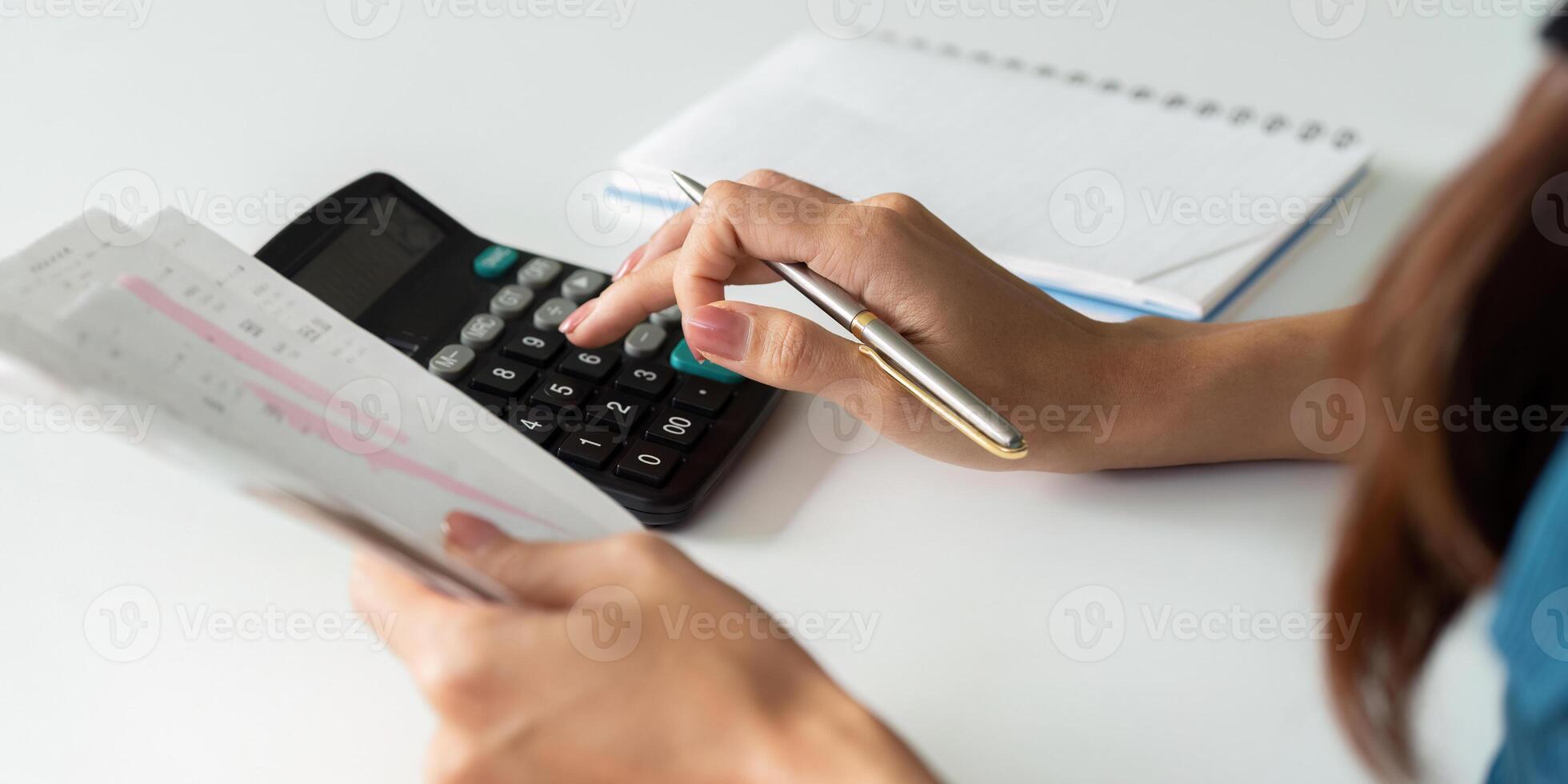 Expense Calculation and Budgeting. An individual engaged in calculating their financial expenditures using a calculator. photo