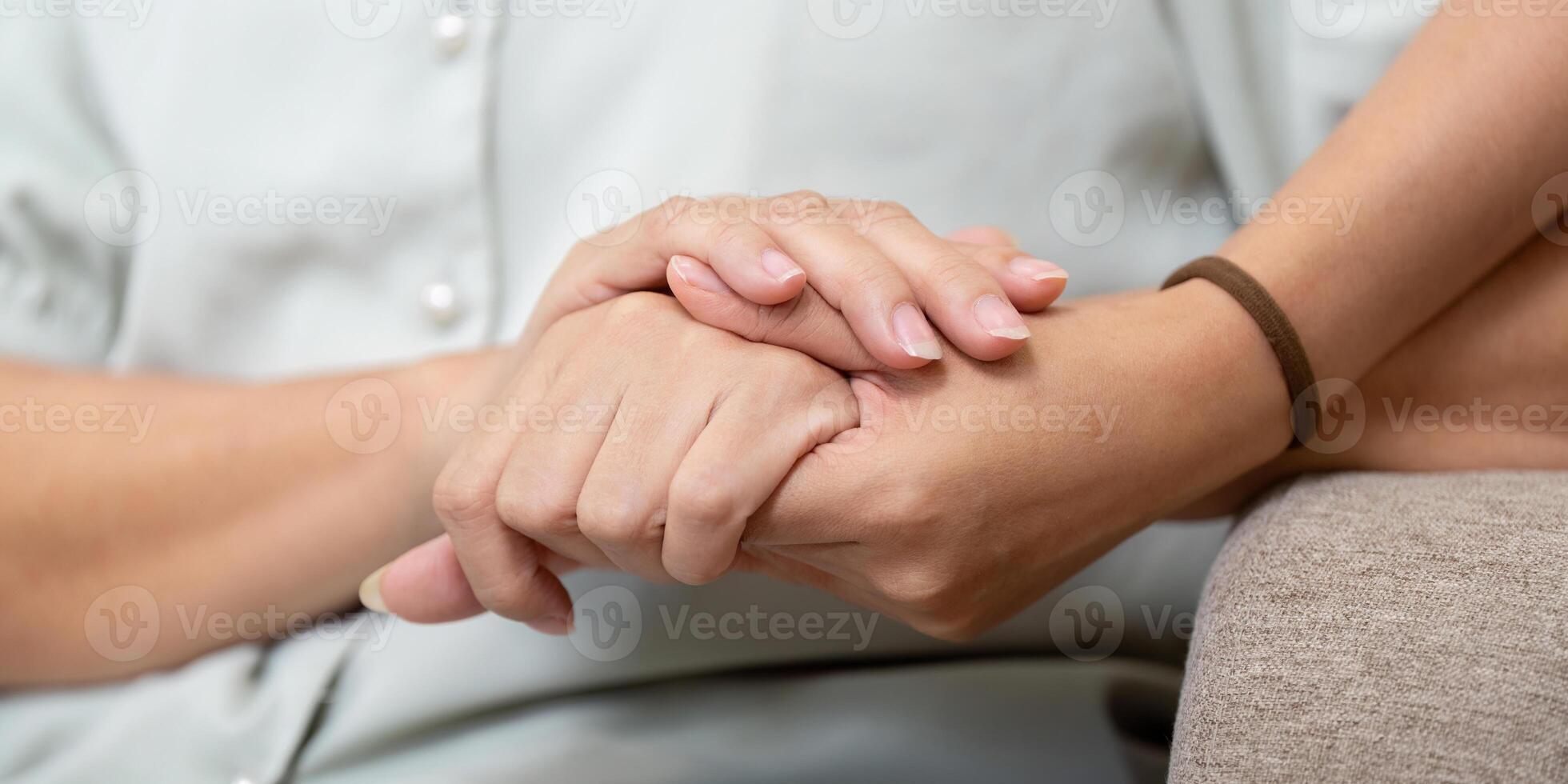 Support and Togetherness. A mother and daughter holding hands to express care and connection. photo