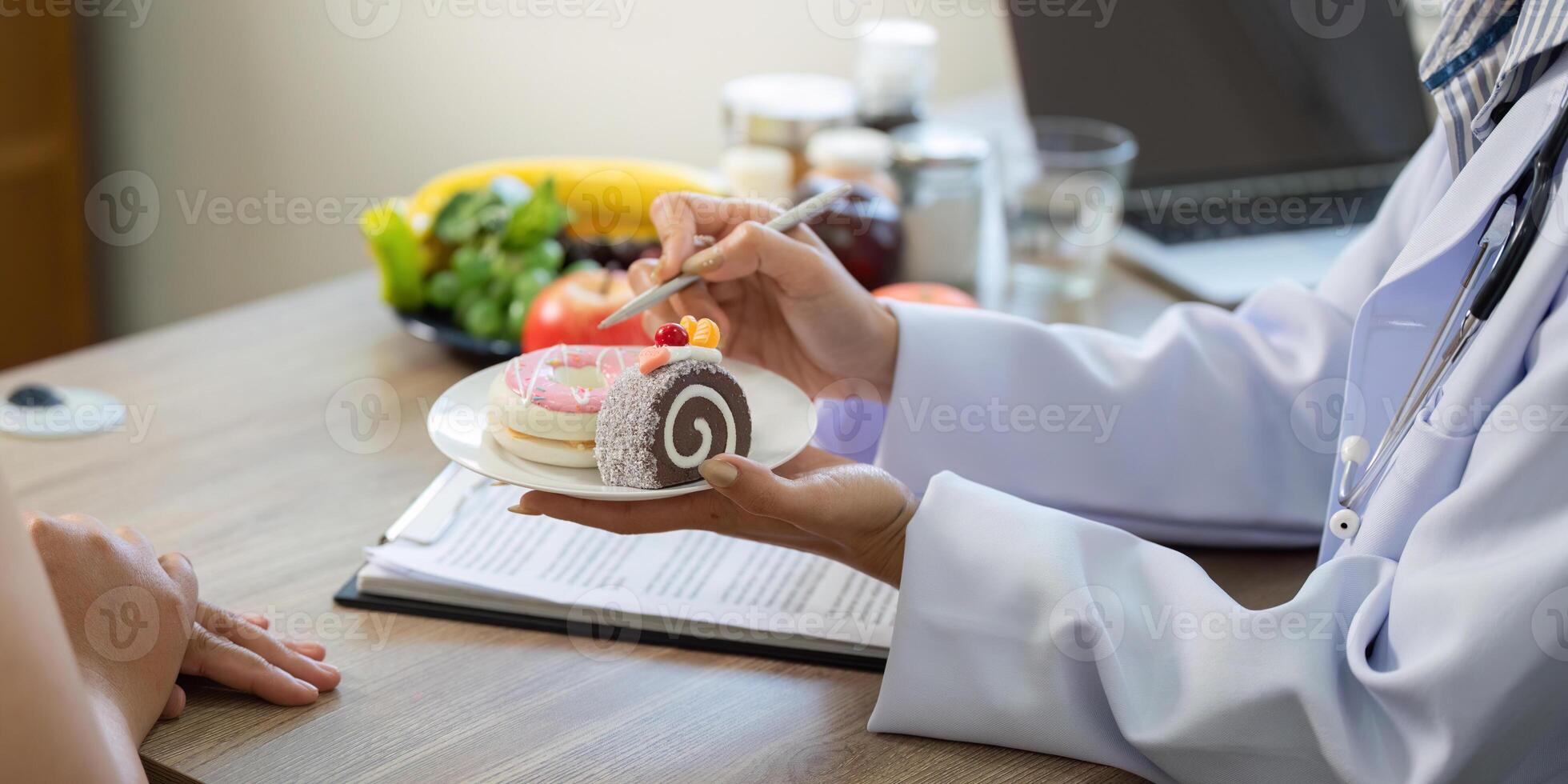 Nutrition and Wellness. A doctor demonstrating healthy dessert options and sugary treats to a patient. photo