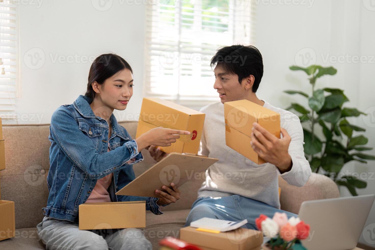 Entrepreneurship and Teamwork. A couple collaborating on an e-commerce project, reviewing packages together with enthusiasm. photo
