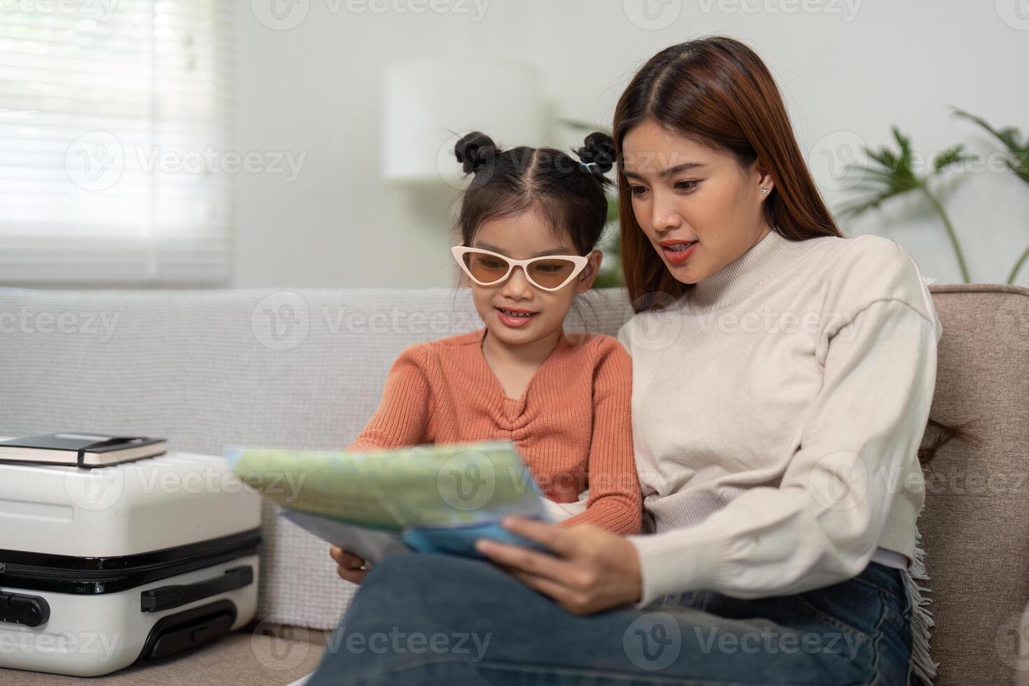 Exploring Destinations Together. A mother and daughter look at maps while planning their travel adventures calmly. photo
