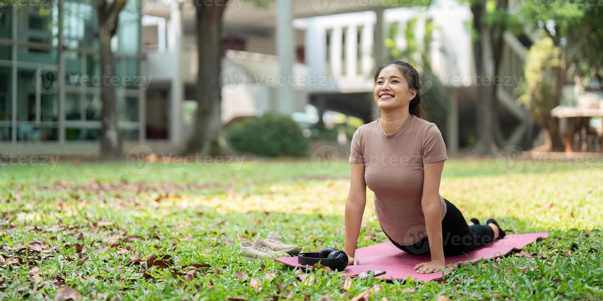 Wellness and Fitness Routine. A woman transitioning into a yoga pose with a smile, embodying relaxation and focus. photo