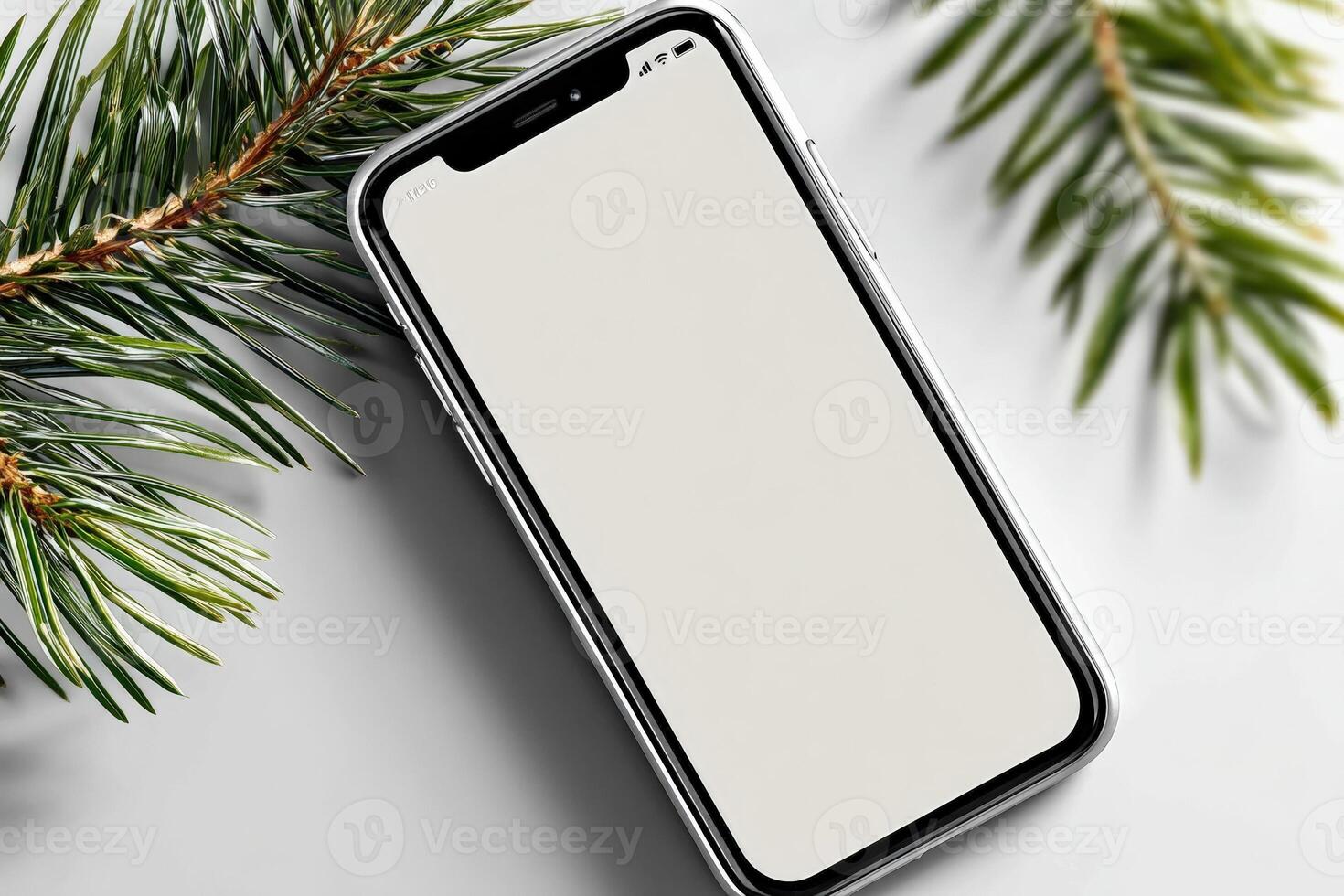 Christmas smartphone resting on a decorative pine branch background with a blank screen ready for holiday photos