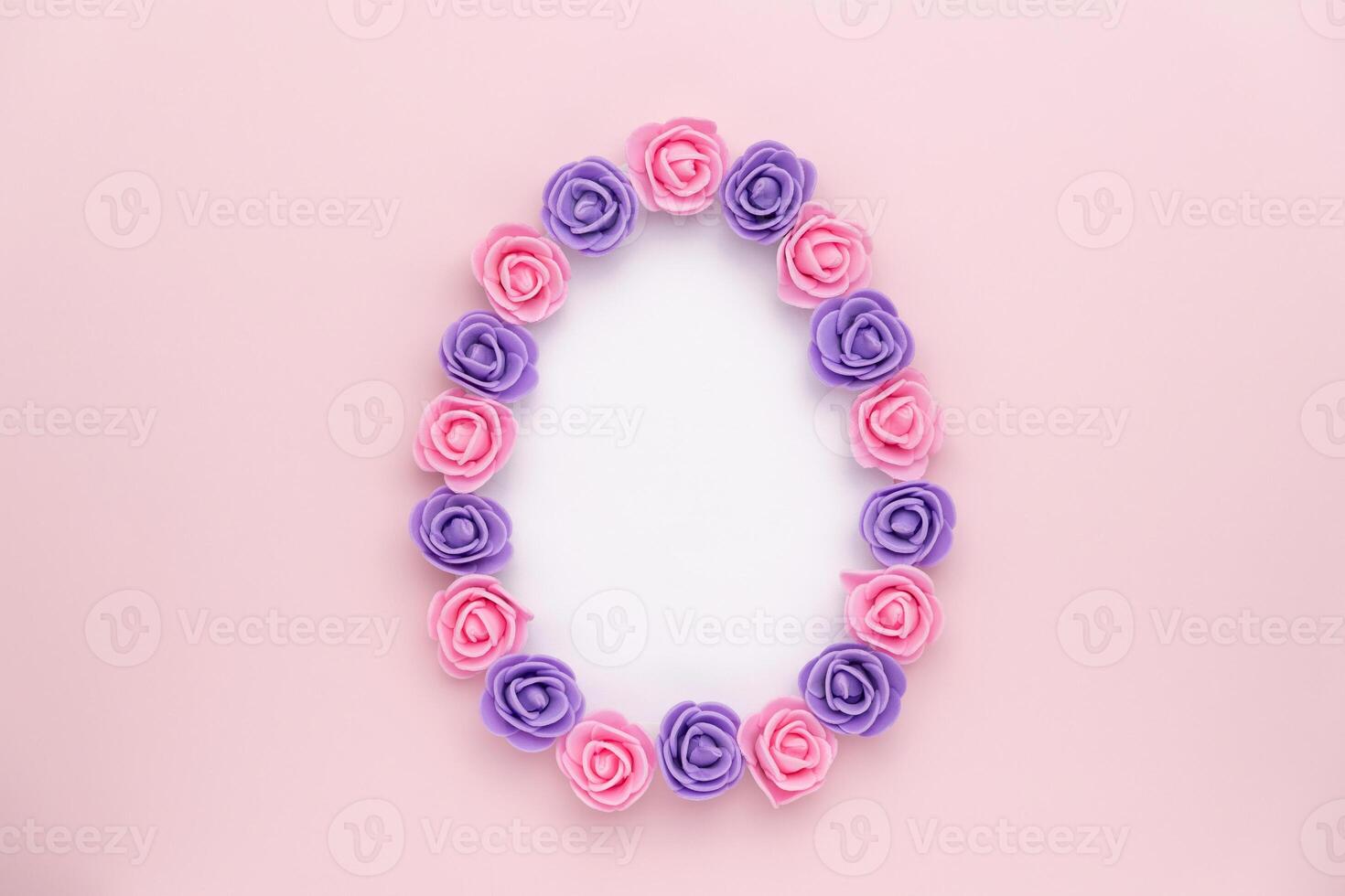 Pastel violet rosebuds egg shape on pink background. Versatile Easter-themed composition perfect for backgrounds, greeting cards, social media, and seasonal marketing. photo