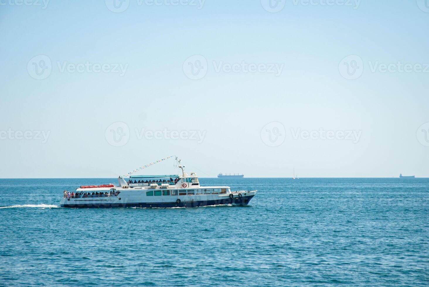 Stunning yacht cruising in clear blue ocean with distant horizon under clear sky. Happy summer days, travel and vacation concept photo