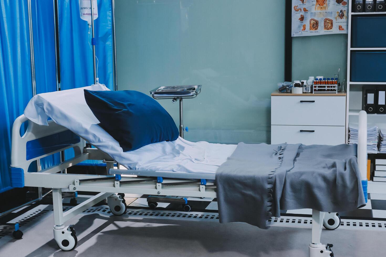 A hospital bed with a blue blanket photo