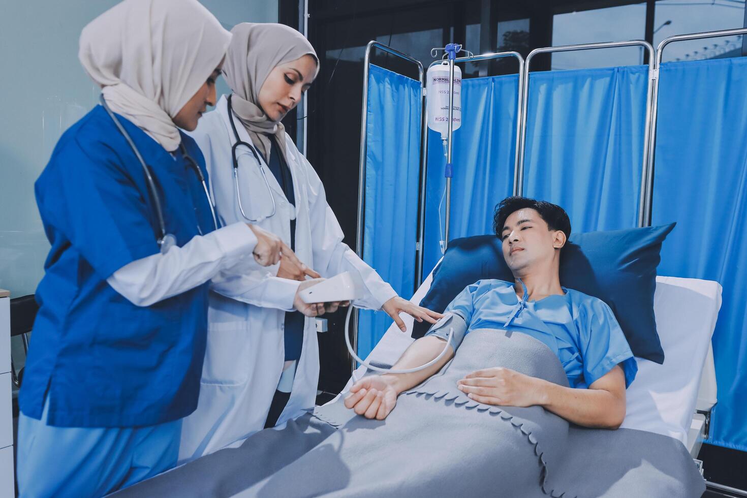 Asian muslim doctor giving blood to patient in hospital photo